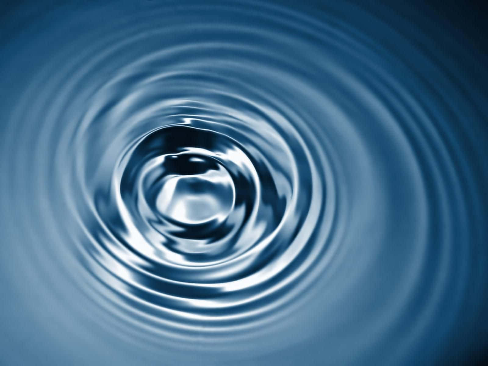 waves 桌布 壁紙 — 中央水滴向外擴散的同心漣漪特寫，採用冷藍色調。