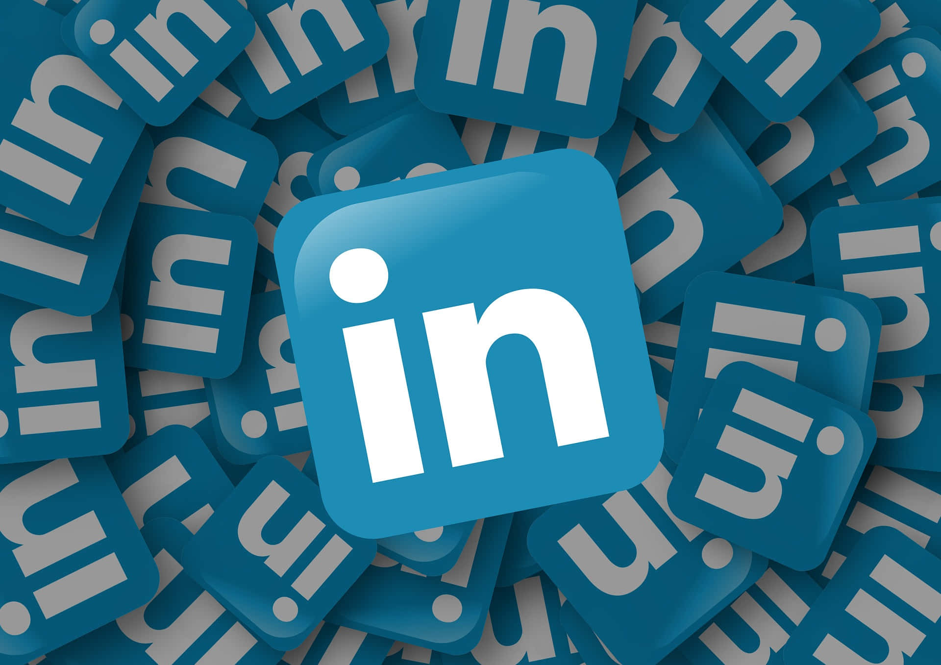 領英 桌布 壁紙 — 中央的 LinkedIn 標誌被重疊的藍色 LinkedIn 圖示包圍，形成密集的數位圖案。
