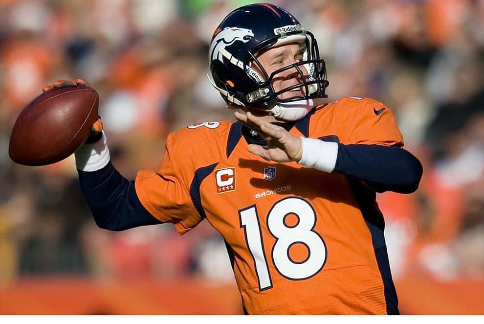 Fantasy Football Profile 桌布 壁紙 — 丹佛野馬隊四分衛佩頓·曼寧身穿橙色18號球衣，在陽光明媚的比賽中準備傳球。