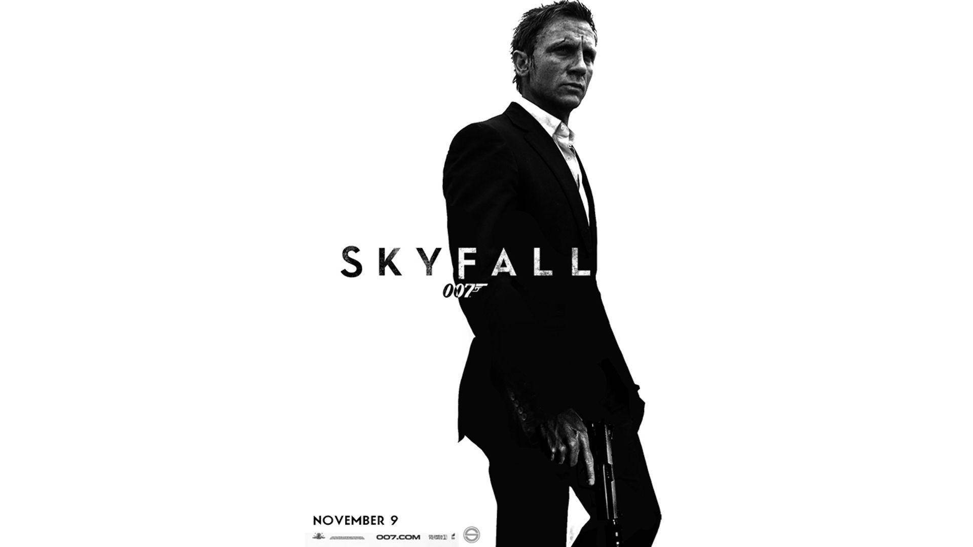Bond 桌布 壁紙 — 丹尼爾·克雷格飾演詹姆士·龐德的黑白肖像，手持槍支，背景為純白色，帶有「SKYFALL」文字。