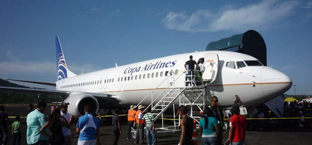  壁紙 — 乘客在晴朗藍天下於機場停機坪登上白色Copa Airlines噴射機。