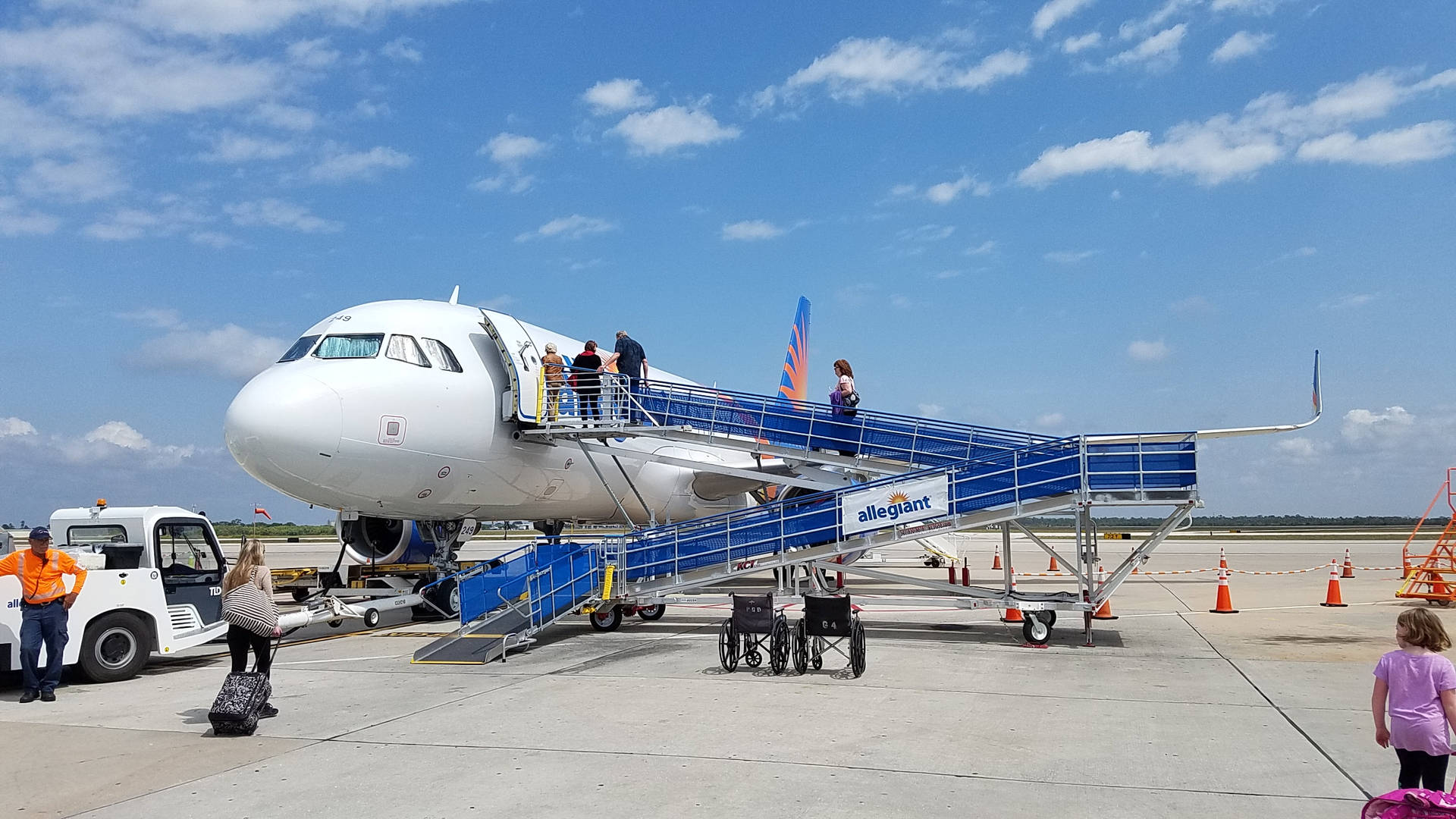 transportation 桌布 壁紙 — 乘客通過藍色移動樓梯登上白色Allegiant Airlines噴射機，天空湛藍，雲朵稀疏。