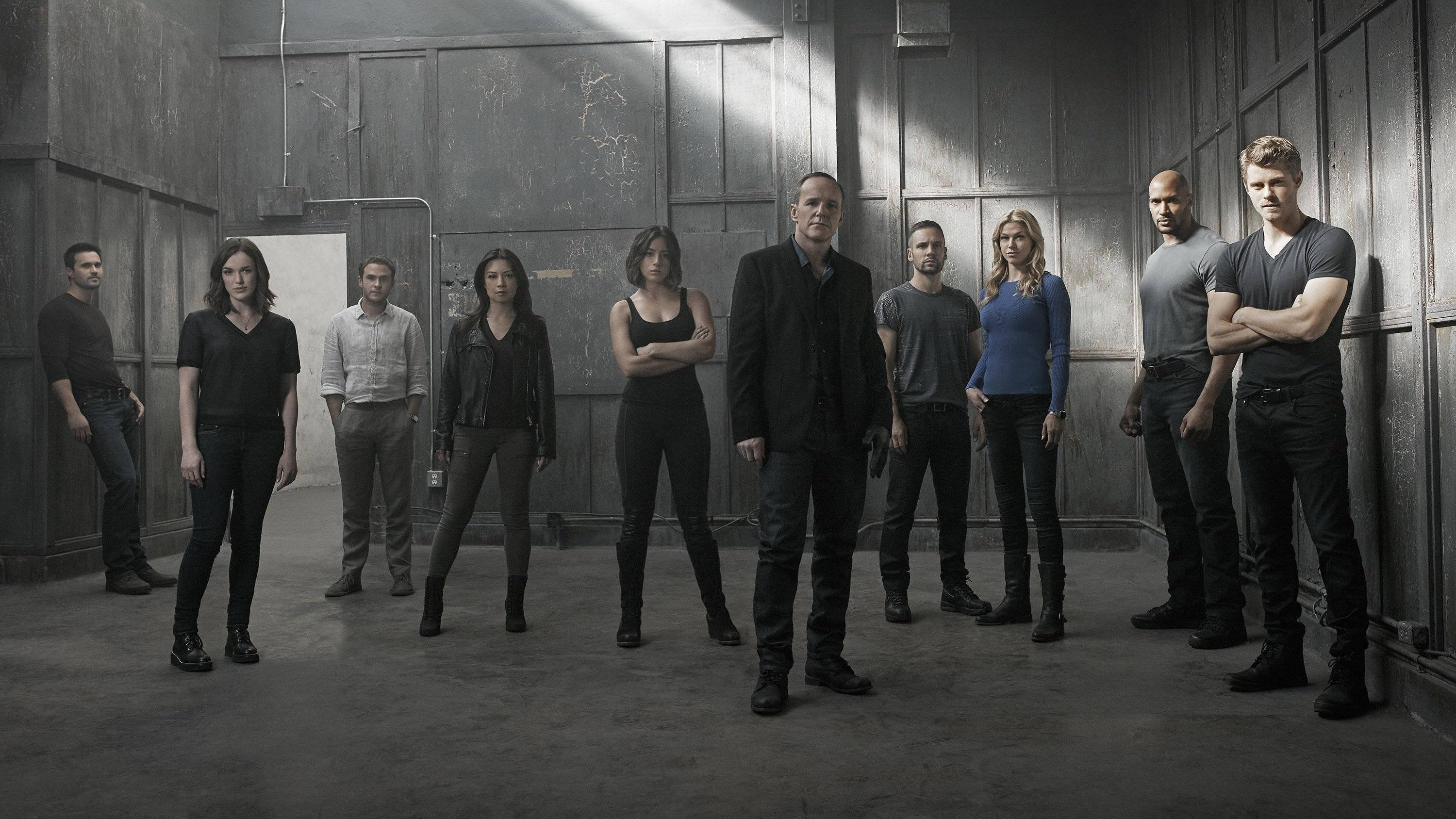 agents of shield 桌布 壁紙 — 九位演員在一個粗糙的工業倉庫中，在強烈的燈光下為一張戲劇性的宣傳照擺姿勢。