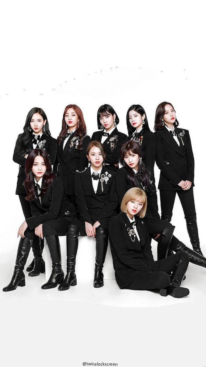 twice 桌布 壁紙 — 九位身穿黑色西裝、搭配花卉胸針的女性，在純白背景前自信地擺姿勢。