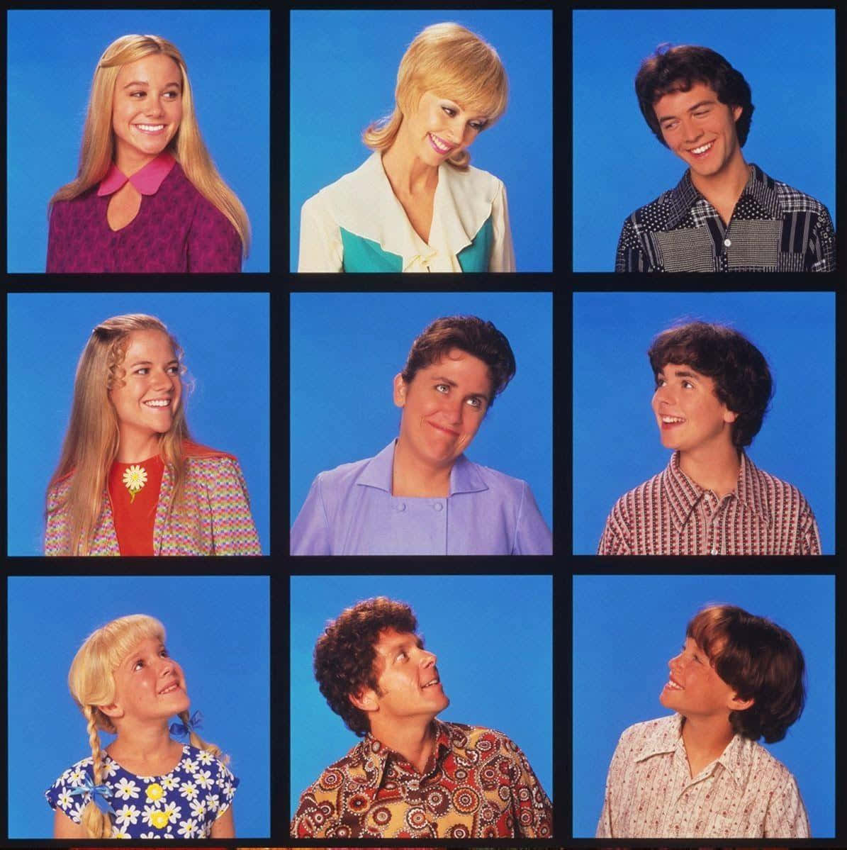 Brady Bunch Zoom 桌布 壁紙 — 九個微笑的人穿著色彩繽紛的1970年代服裝，在純藍色攝影棚背景前以網格佈局擺姿勢。