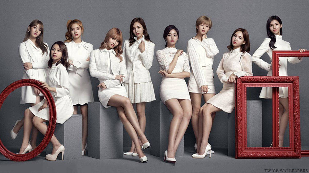 twice 桌布 壁紙 — 九名身穿白色服裝的女性在灰色工作室背景前自信地擺姿勢，手持華麗的紅色相框。