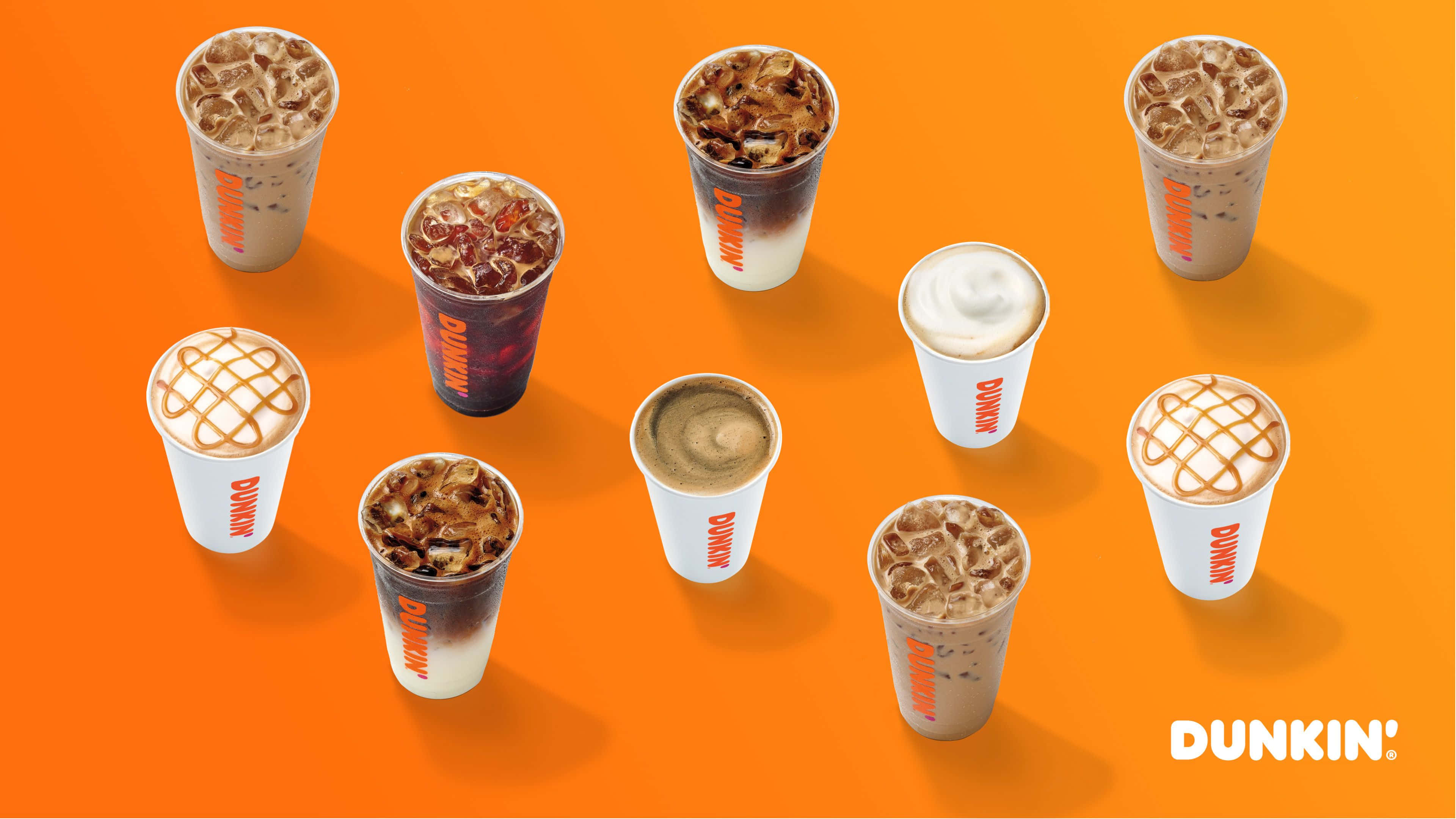 Dunkin Donuts 桌布 壁紙 — 九杯Dunkin'冰咖啡飲品放在品牌杯中，排列在鮮豔的橙色背景上。