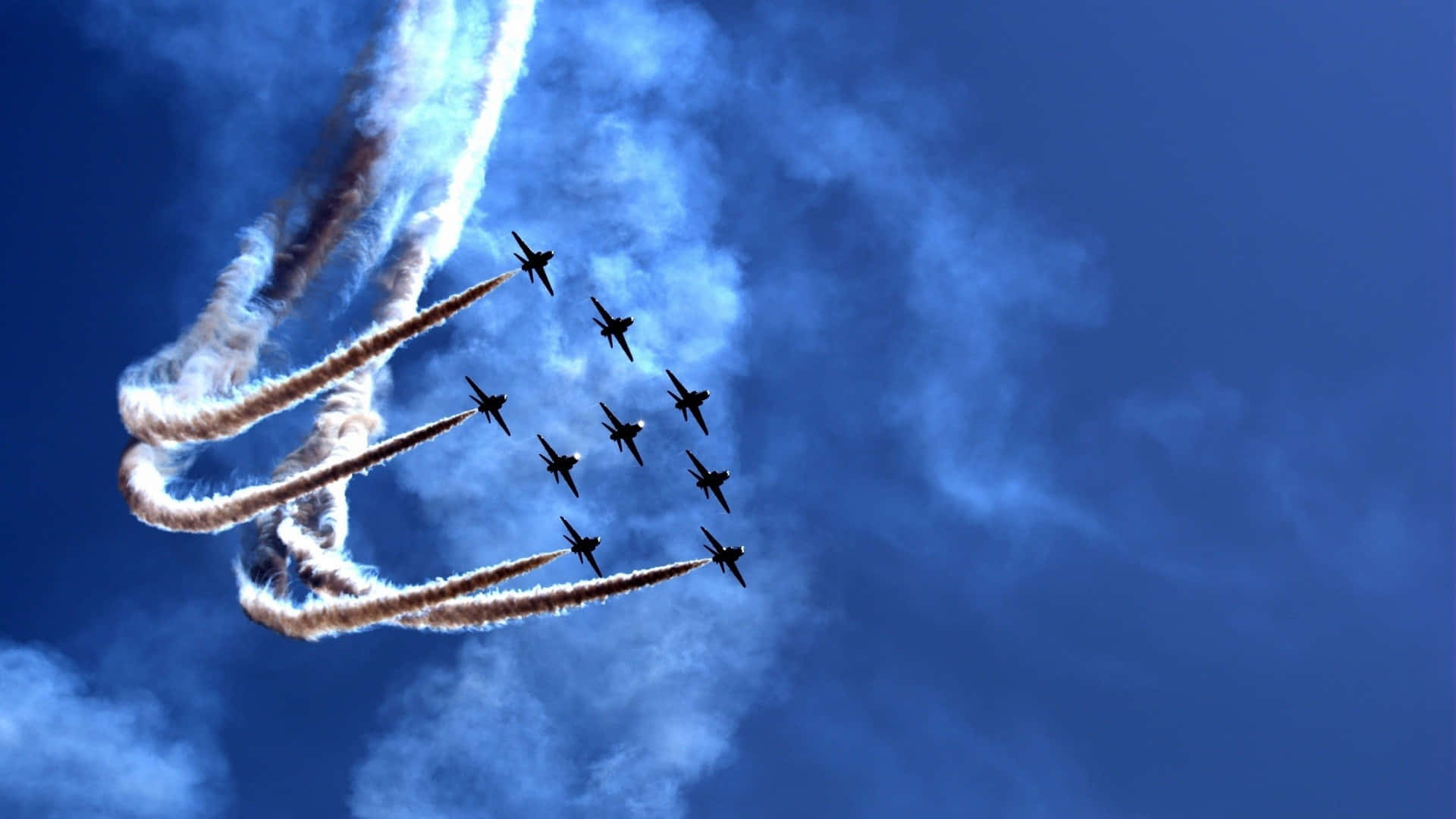 Air Force 桌布 壁紙 — 九架戰鬥機在深藍色的天空中緊密編隊飛行，留下濃厚的白色煙霧痕跡。