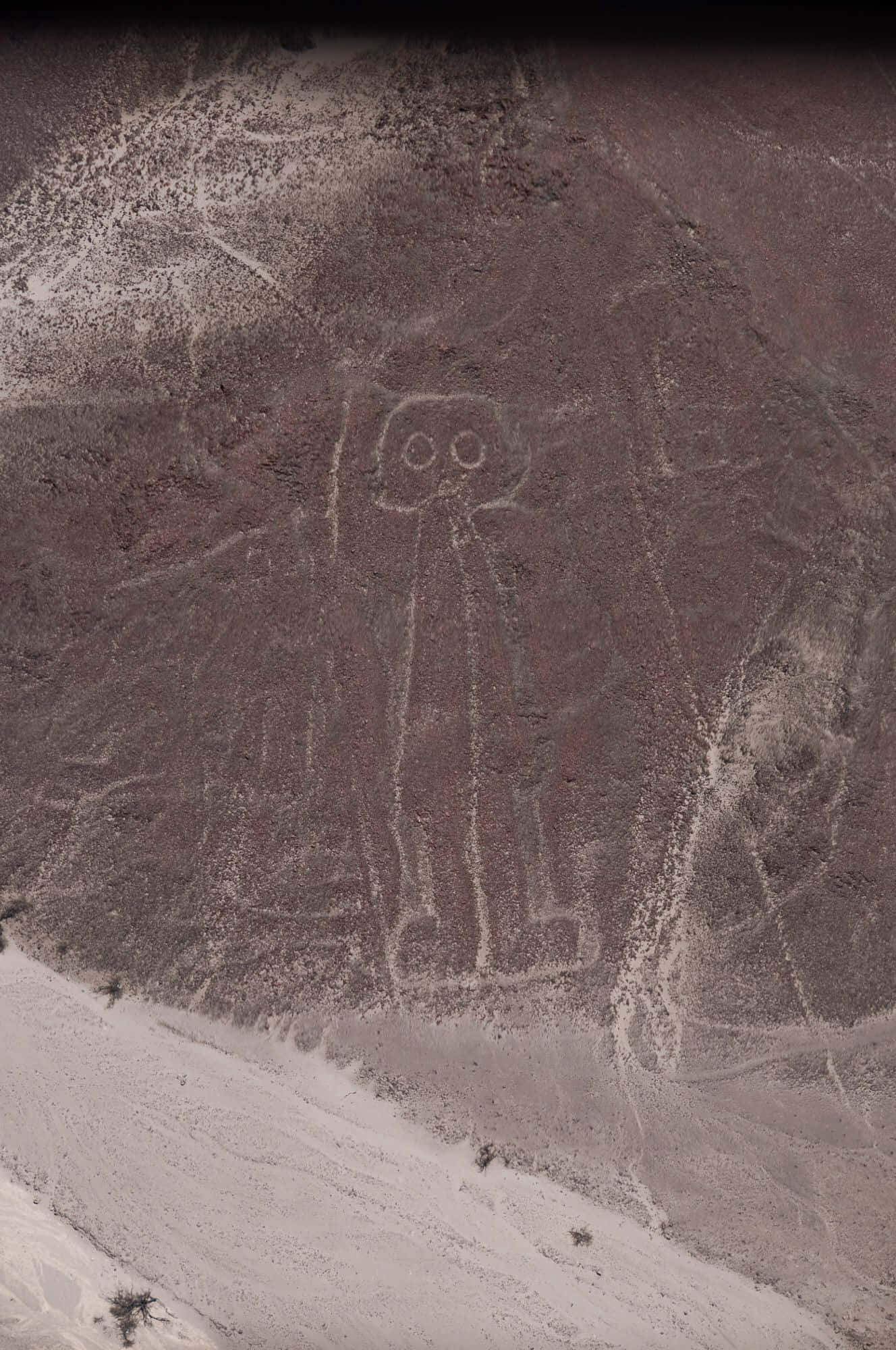 The Nazca Lines 桌布 壁紙 — 乾燥沙漠地形上刻有圓形眼睛的風格化人形古代地畫的鳥瞰圖。
