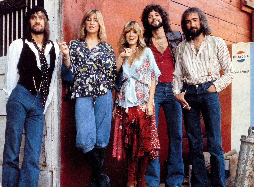 band 桌布 壁紙 — 五位1970年代搖滾樂團成員穿著喇叭褲和圖案襯衫，自信地在紅色木牆和百事可樂標誌前擺姿勢。