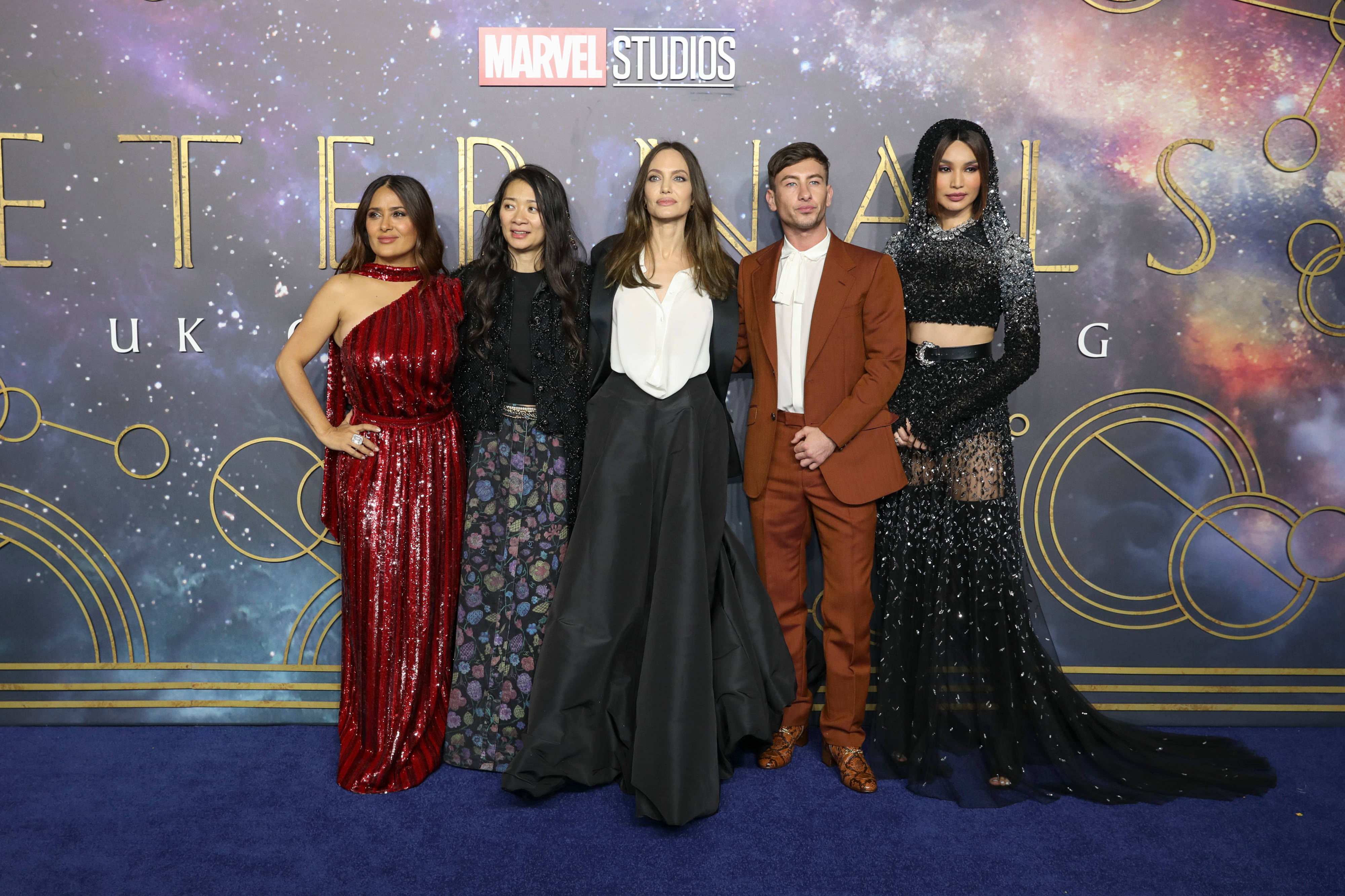 Salma 桌布 壁紙 — 五位名人在藍色地毯上擺姿勢，背景是Marvel Studios的宇宙主題佈景，為《永恆族》英國首映禮。