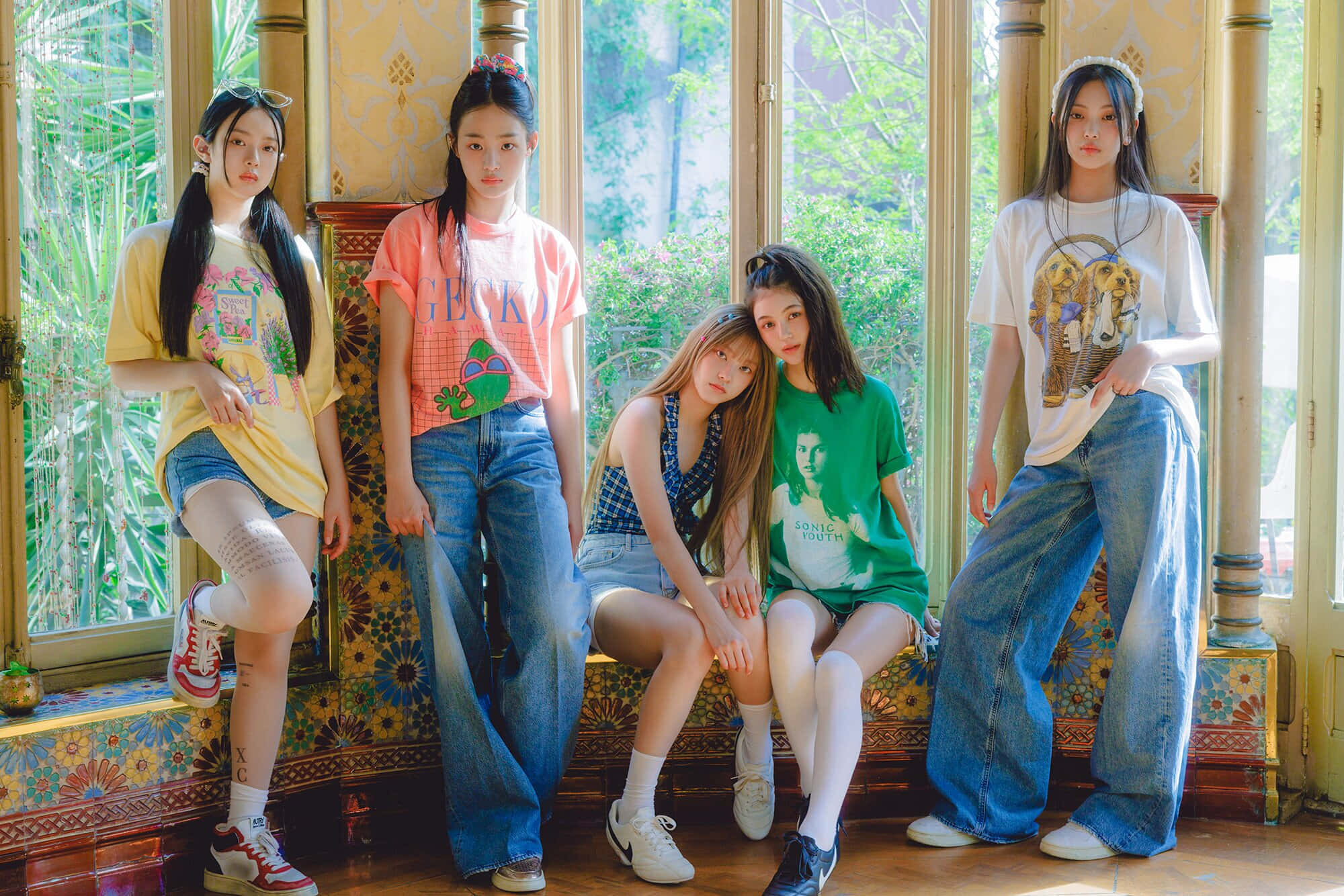 女孩 桌布 壁紙 — 五位年輕女性穿著色彩繽紛的休閒服裝，在一個陽光充足、裝飾華麗、帶有大窗戶的房間裡，自信地坐在花卉圖案的長椅上擺姿勢。