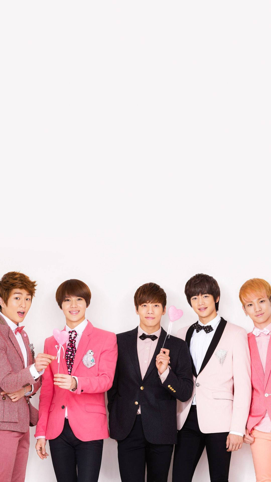 Shinee 桌布 壁紙 — 五位年輕男士穿著時尚的粉紅色和黑色西裝，在純白色背景前開心地擺姿勢，手持心形道具。