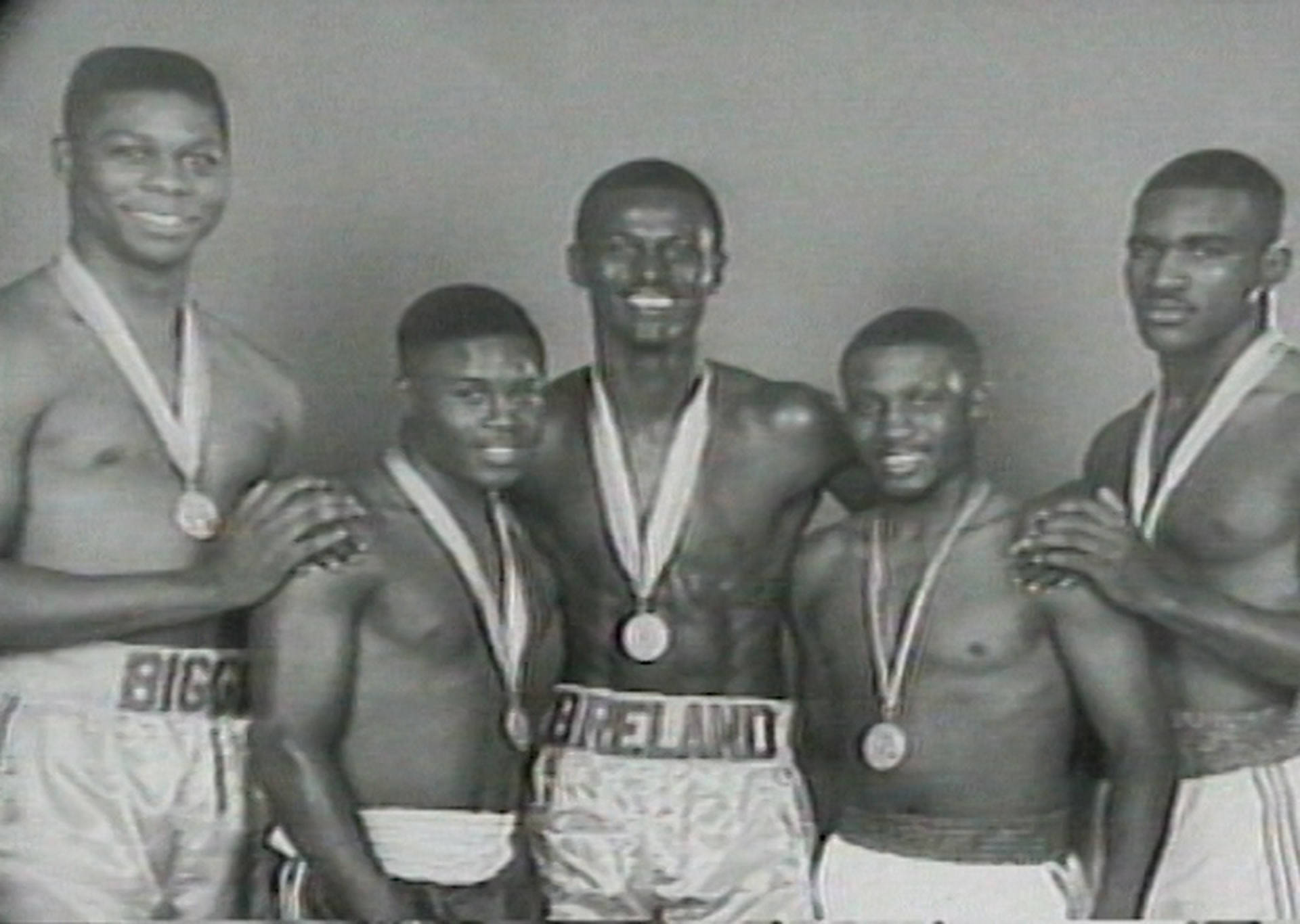 Boxing 桌布 壁紙 — 五位微笑的黑人拳擊手穿著復古短褲，脖子上掛著獎牌，在經典的黑白工作室肖像中自豪地擺姿勢。