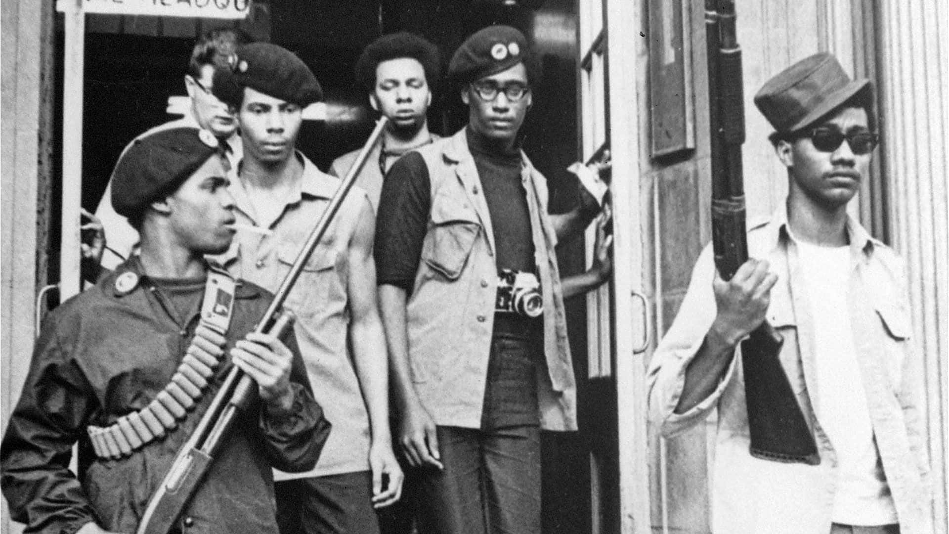 Black Panther Party 桌布 壁紙 — 五位戴貝雷帽的武裝男子站在門口，表情嚴肅的黑白照片。