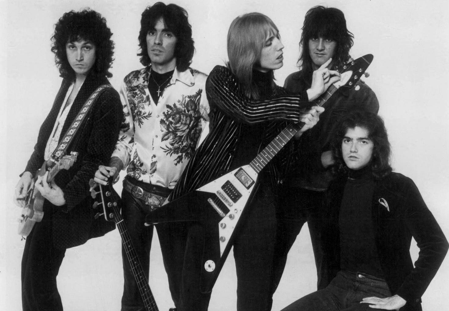 rock n roll 桌布 壁紙 — 五位搖滾音樂家自信地拿著電吉他，在純白色背景前擺姿勢，是一張經典的黑白工作室照片。