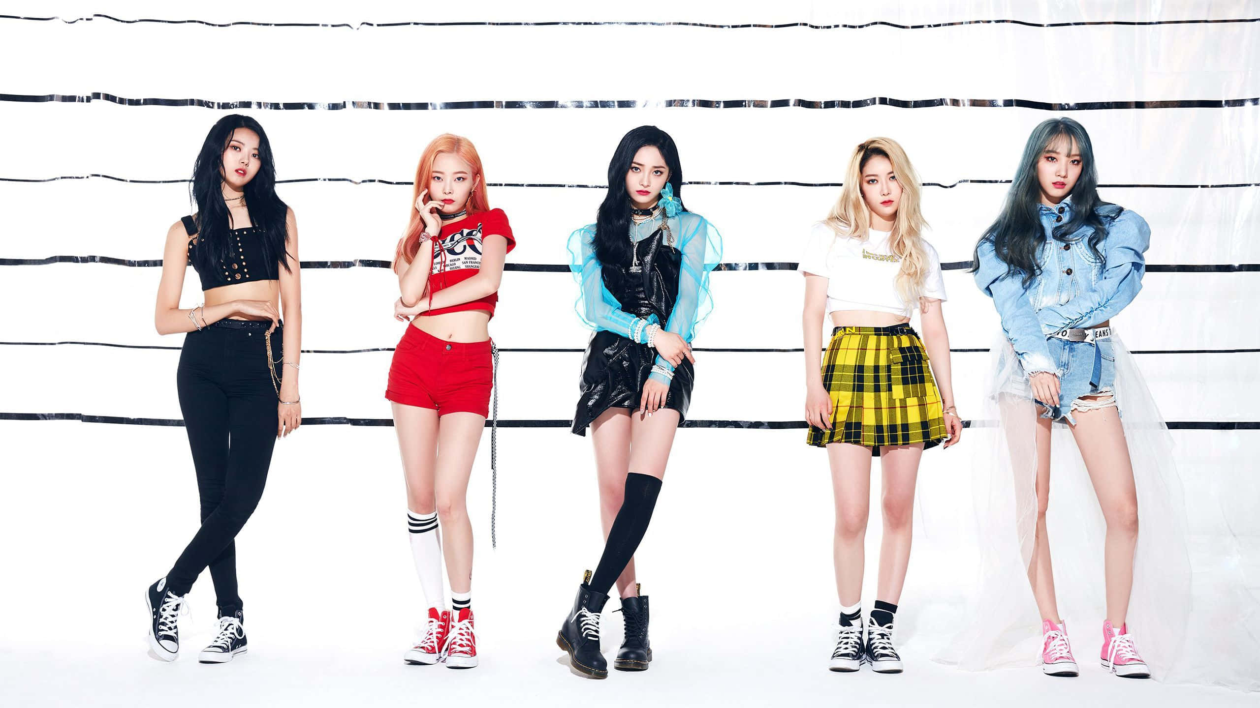 K-pop 桌布 壁紙 — 五位時尚年輕女性穿著大膽服裝，在帶有黑色水平條紋的純白背景前自信地擺姿勢。