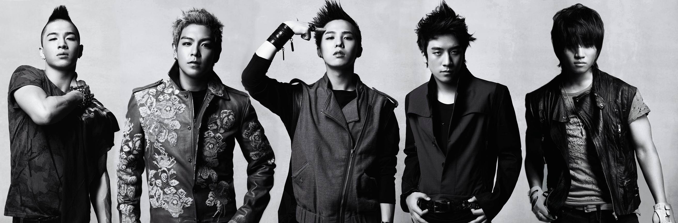 Bigbang 桌布 壁紙 — 五位時尚年輕男士穿著前衛服裝，在純色背景前自信擺姿勢，拍攝出戲劇性的黑白工作室照片。