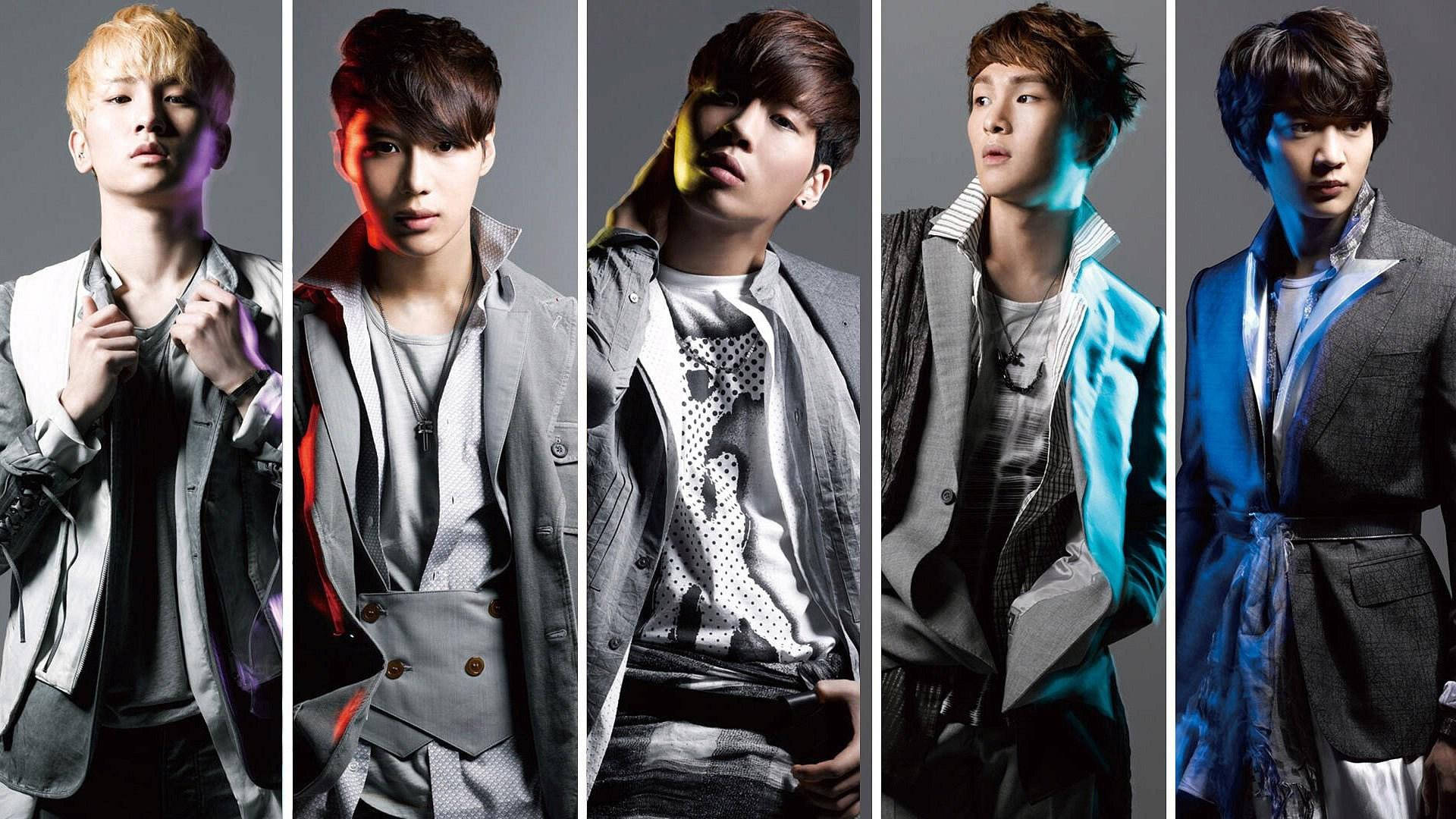 Shinee 桌布 壁紙 — 五位時尚年輕男士穿著時尚外套，在帶有戲劇性彩色照明的深色工作室背景下擺姿勢。