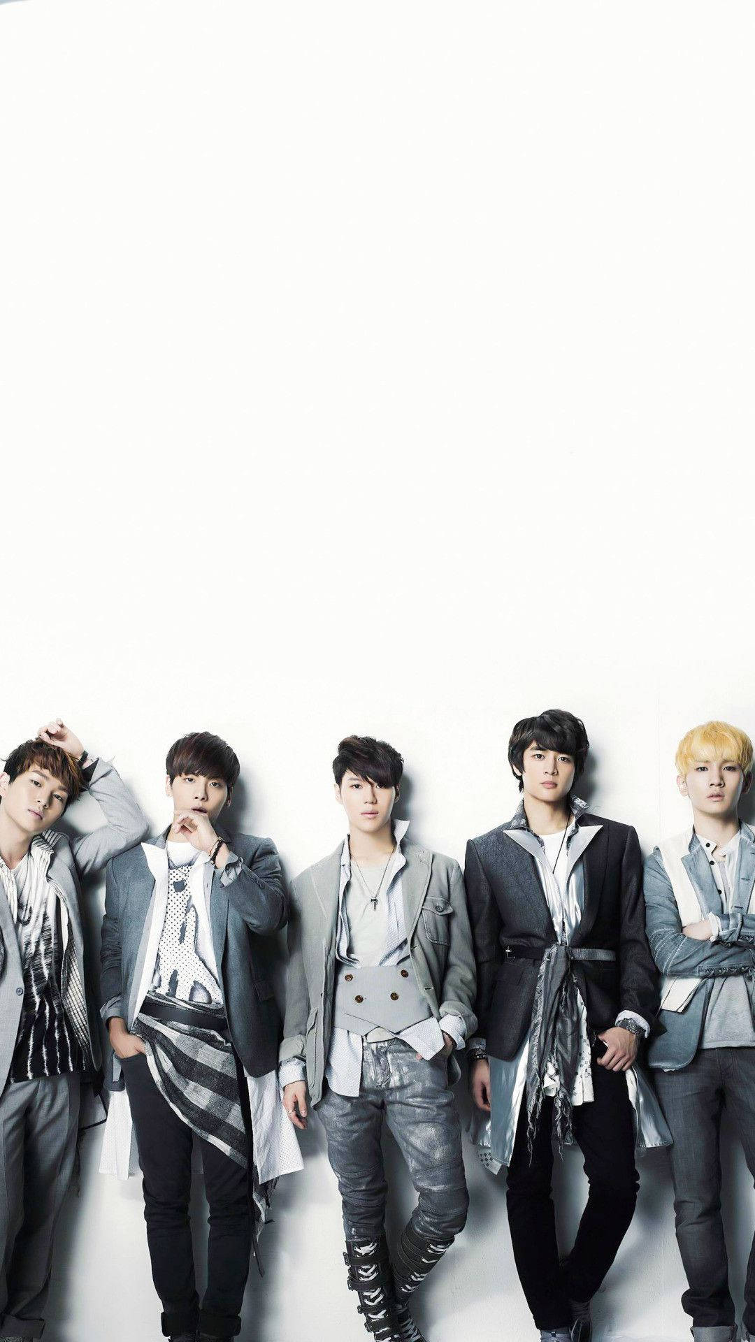 Shinee 桌布 壁紙 — 五位時尚年輕男士穿著潮流灰色服裝，在純白背景前自信地擺姿勢。
