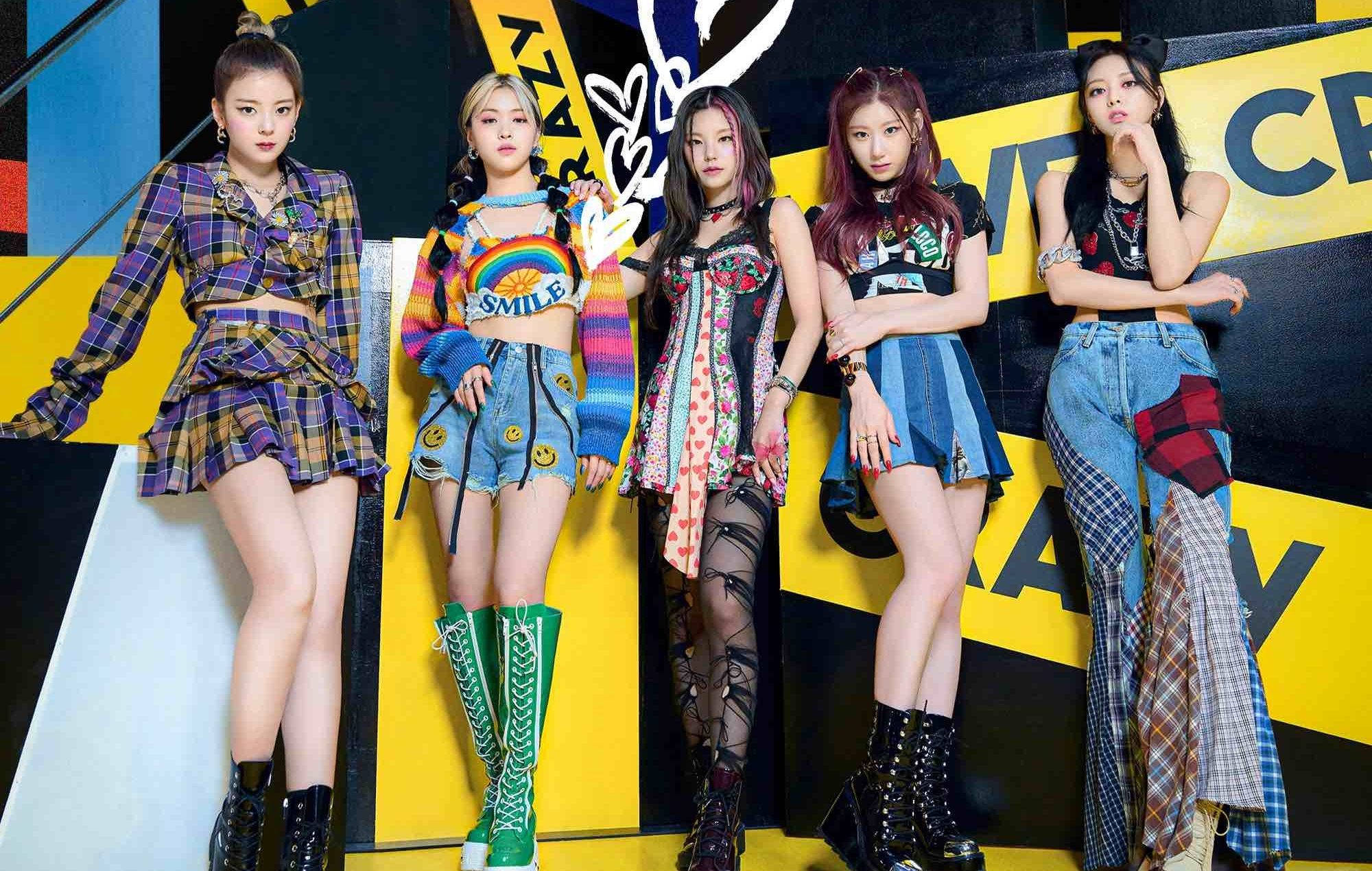 ITZY 桌布 壁紙 — 五位時尚的K-pop偶像在搶眼的黃黑圖案牆前，自信地擺出姿勢，身穿色彩繽紛、風格混搭的服裝。