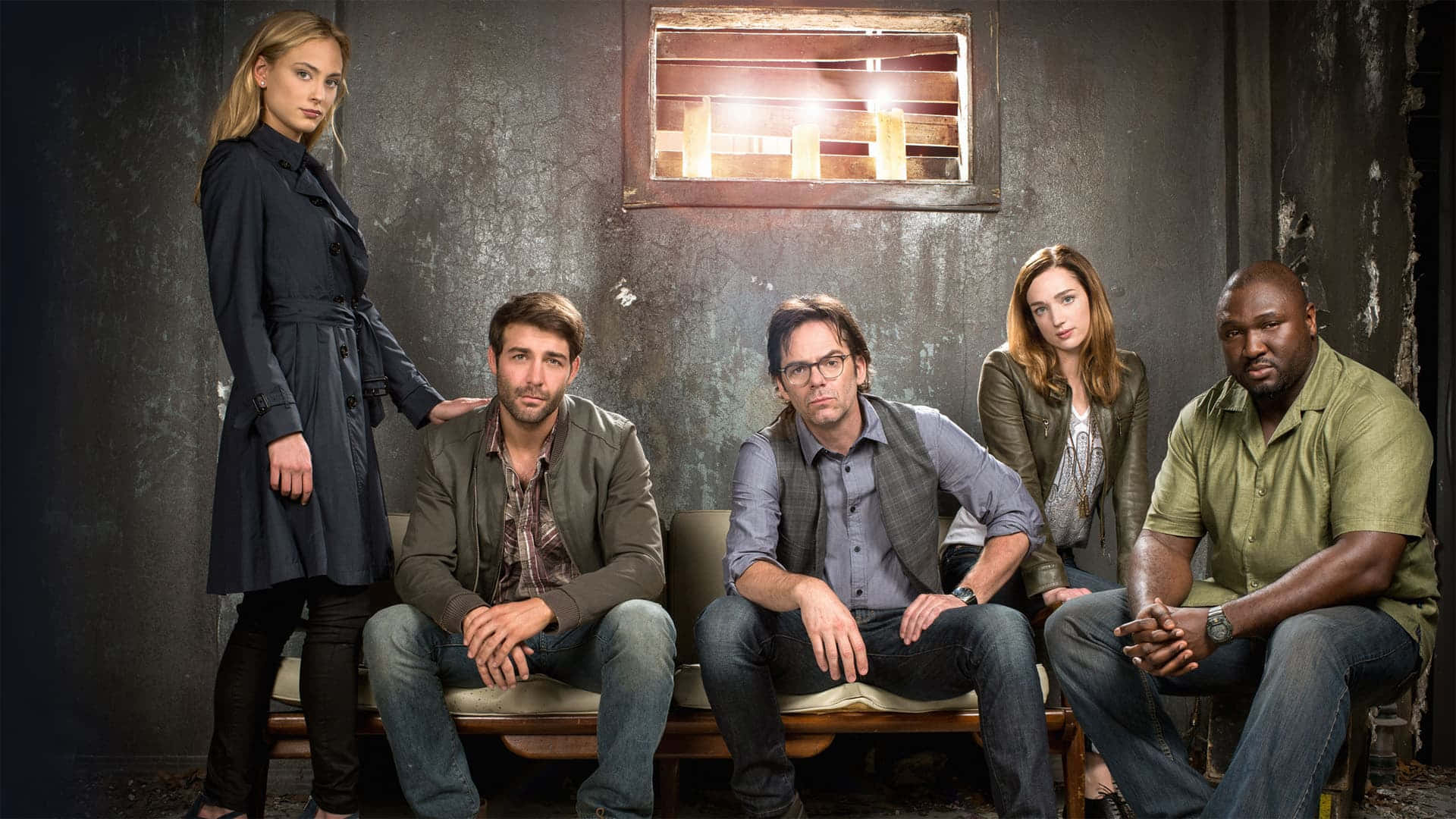 Tv Series 桌布 壁紙 — 五位演員在一個光線昏暗、粗糙的房間裡，在一張破舊的長椅上嚴肅地擺姿勢，身後有一扇窗戶發光。