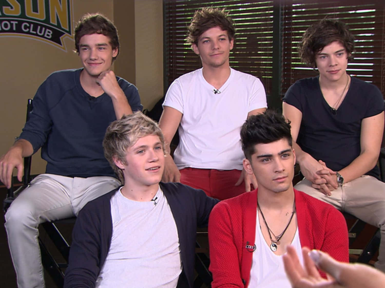 One Direction 桌布 壁紙 — 五位穿著休閒服裝的年輕男性在訪問期間一起坐在錄影棚內。
