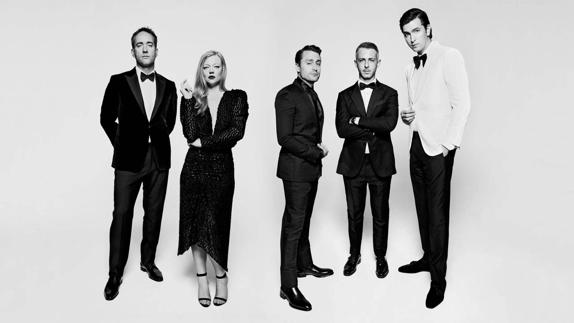 Succession 桌布 壁紙 — 五位穿著正式服裝的優雅人士在純白背景前自信地擺姿勢，呈現出引人注目的黑白肖像。