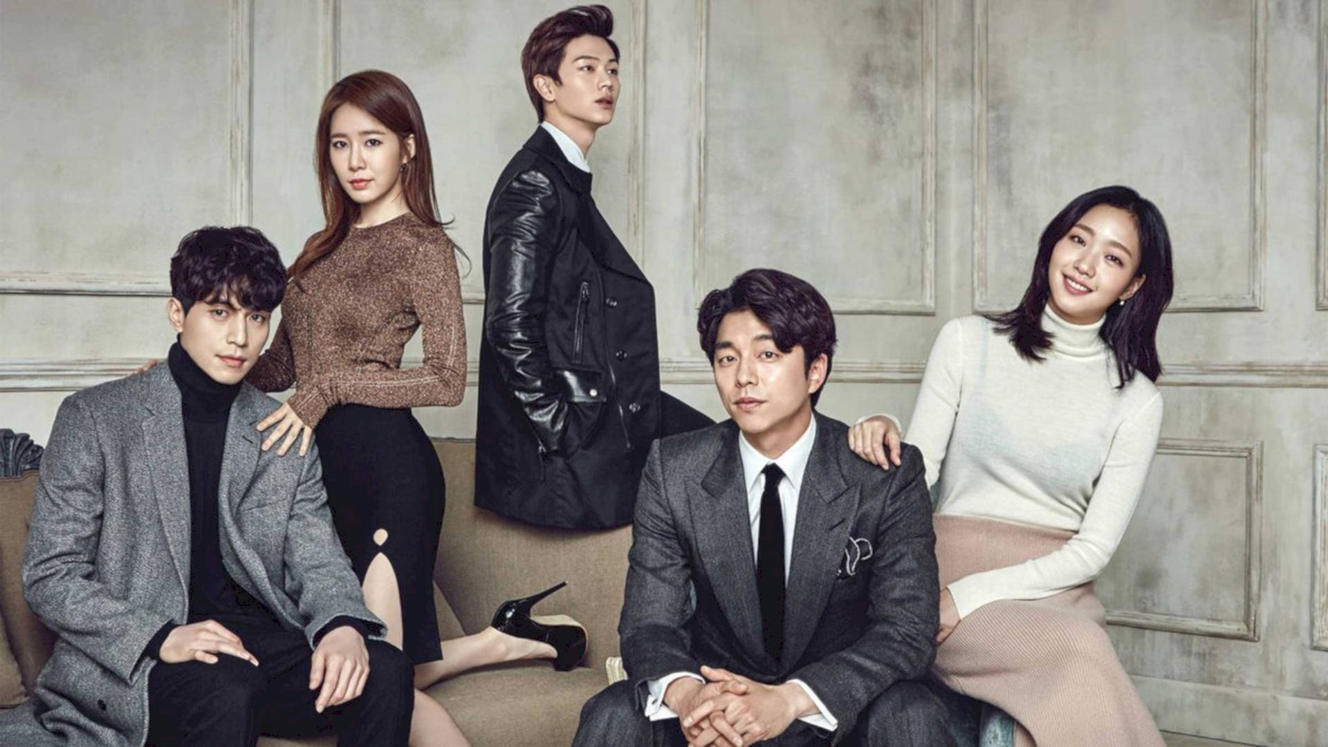 kdrama 桌布 壁紙 — 五位衣著時尚的韓國演員在米色沙發上自信地擺姿勢，背景是柔和的灰色鑲板牆。