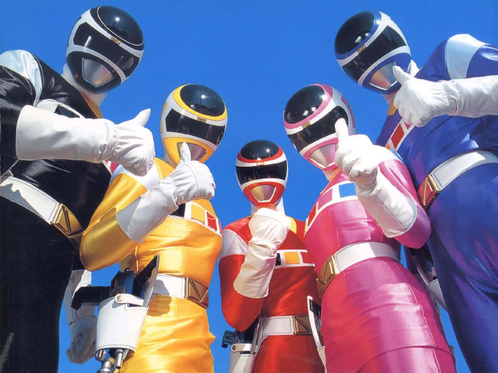 金剛戰士 桌布 壁紙 — 五位身穿色彩繽紛服裝的Power Rangers在晴朗的藍天下豎起大拇指。