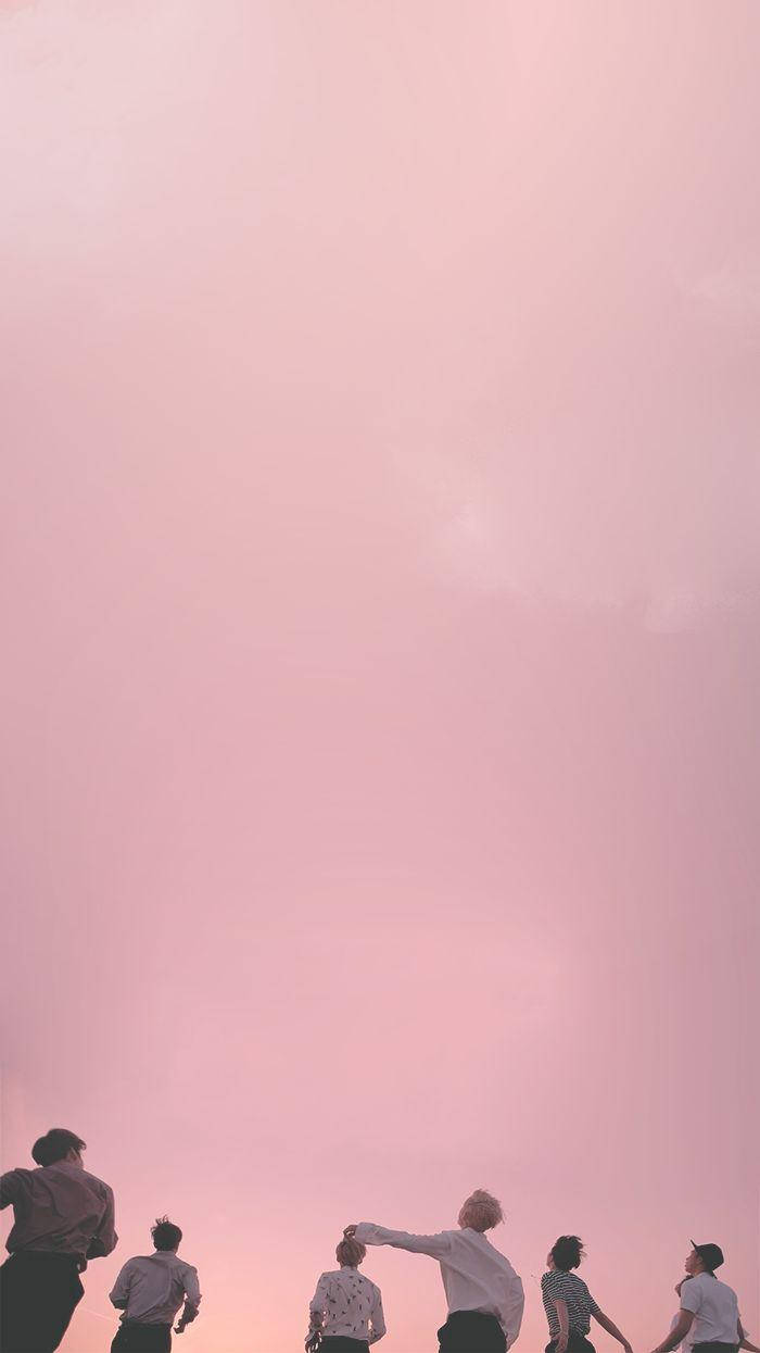 美學 Tumblr 桌布 壁紙 — 五個人站在廣闊的粉紅色日落天空下形成剪影，其中一人驚奇地指向天空。