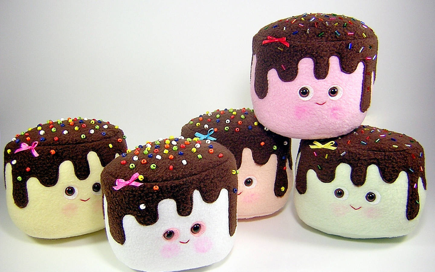 五個微笑的毛絨棉花糖，帶有巧克力和糖粒。 — Squishmallows 壁紙