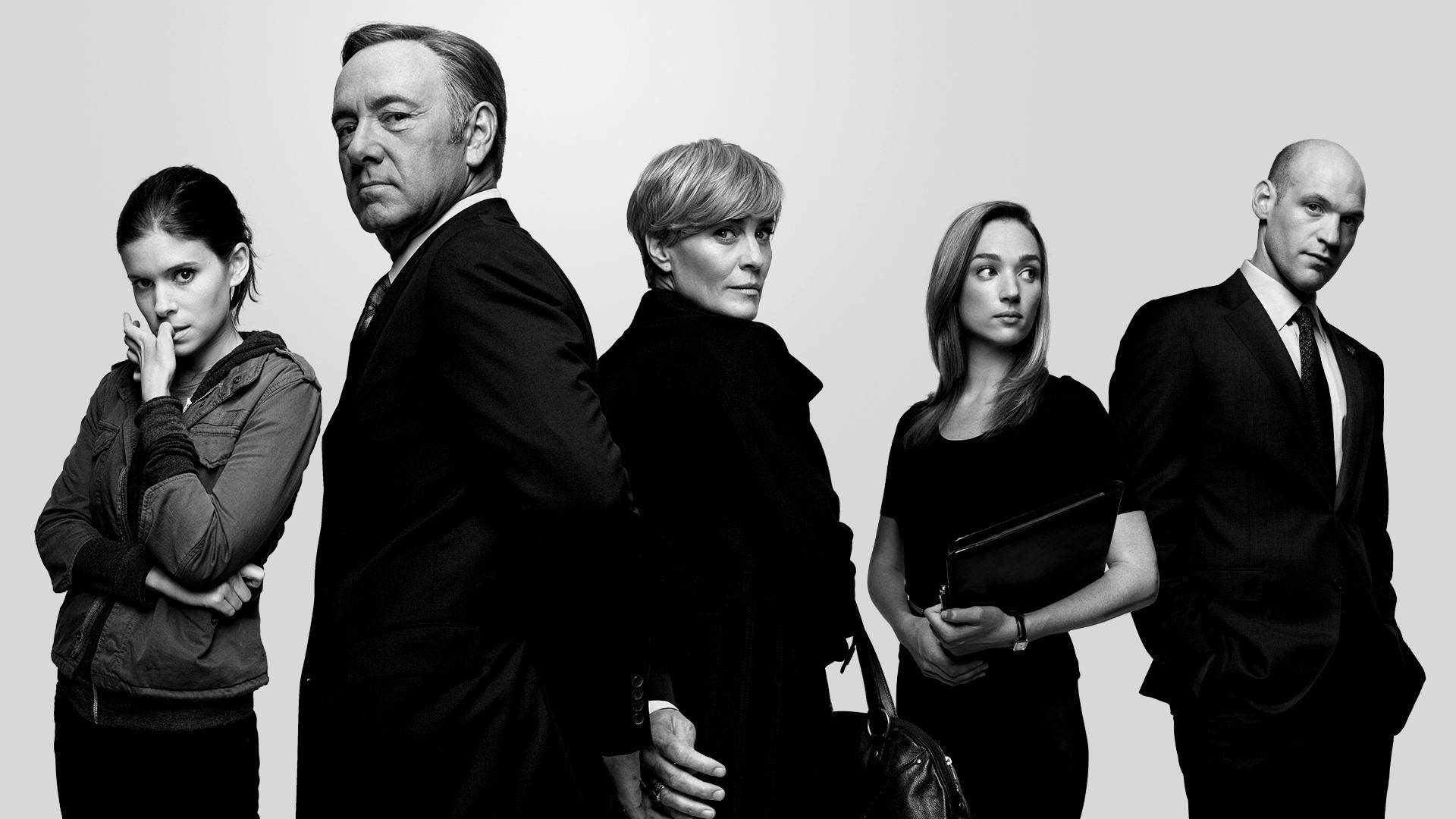 kevin spacey 桌布 壁紙 — 五個嚴肅的黑白角色排成一排，站在素色背景前，散發出緊張和權威感。