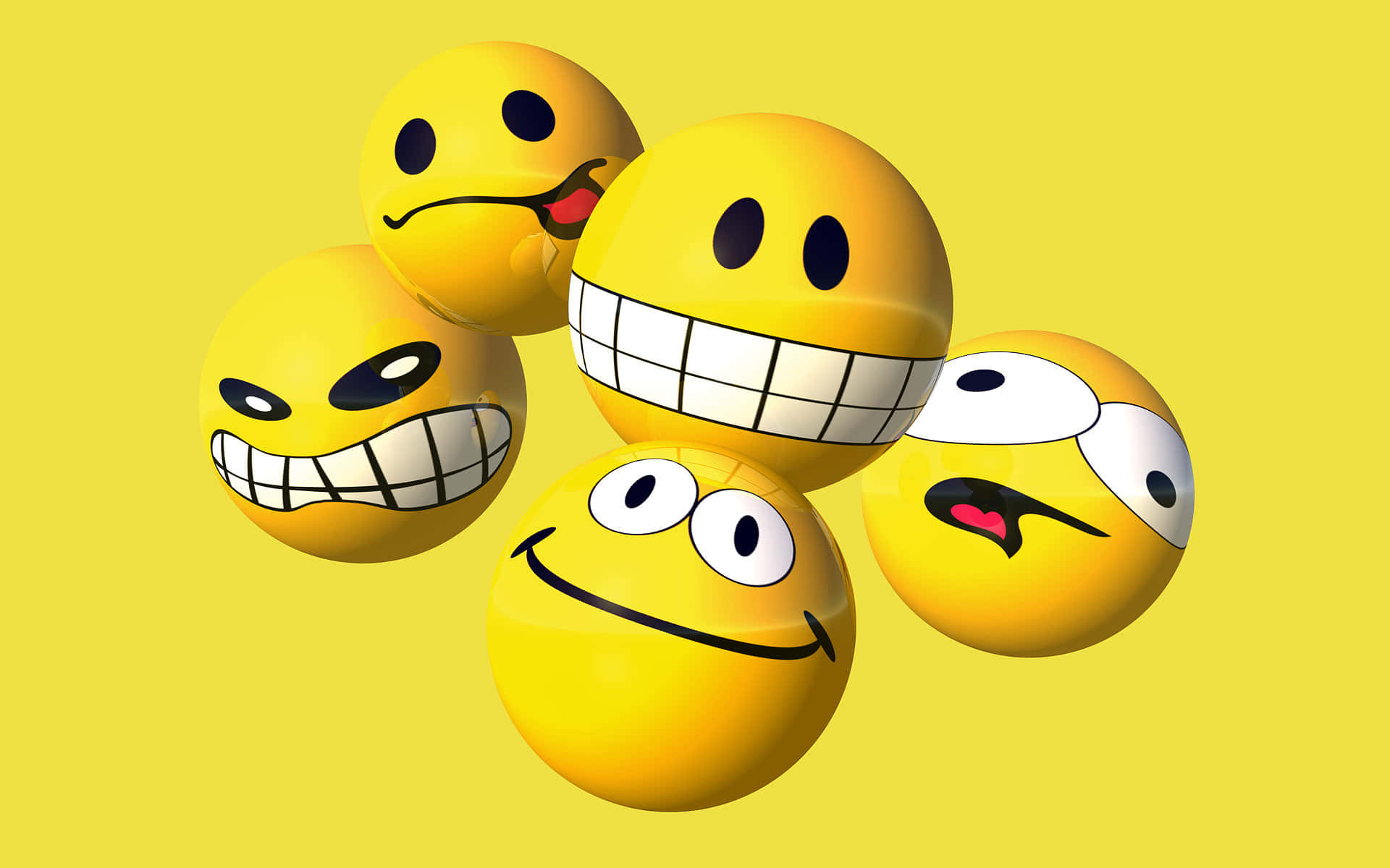 Smiley 桌布 壁紙 — 五個帶有不同頑皮表情的光澤黃色表情符號球體漂浮在純黃色背景上。