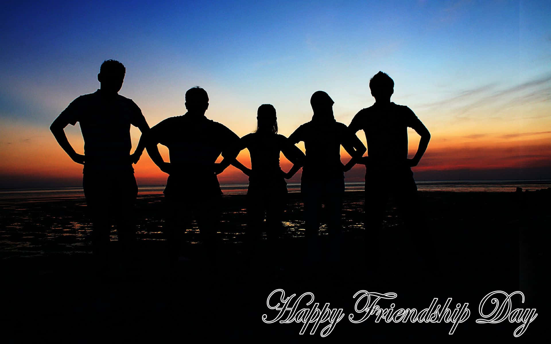 Friendship Day 桌布 壁紙 — 五個朋友在日落時分以剪影姿態站在沙灘上，雙手叉腰，背景是充滿活力的橙色和藍色天空。