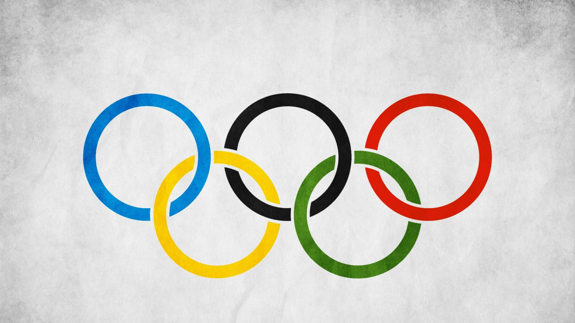 Olympics 桌布 壁紙 — 五個相互交織的奧運環，顏色為藍、黃、黑、綠和紅，位於有紋理的灰色背景上。
