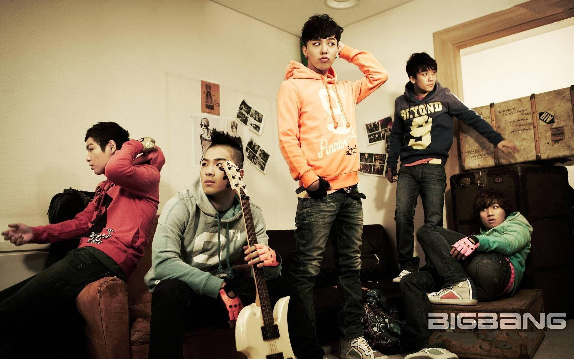 Bigbang 桌布 壁紙 — 五個穿著休閒服的年輕男子在一個雜亂的房間裡戲劇性地擺姿勢，房間裡有復古行李箱和牆上照片。