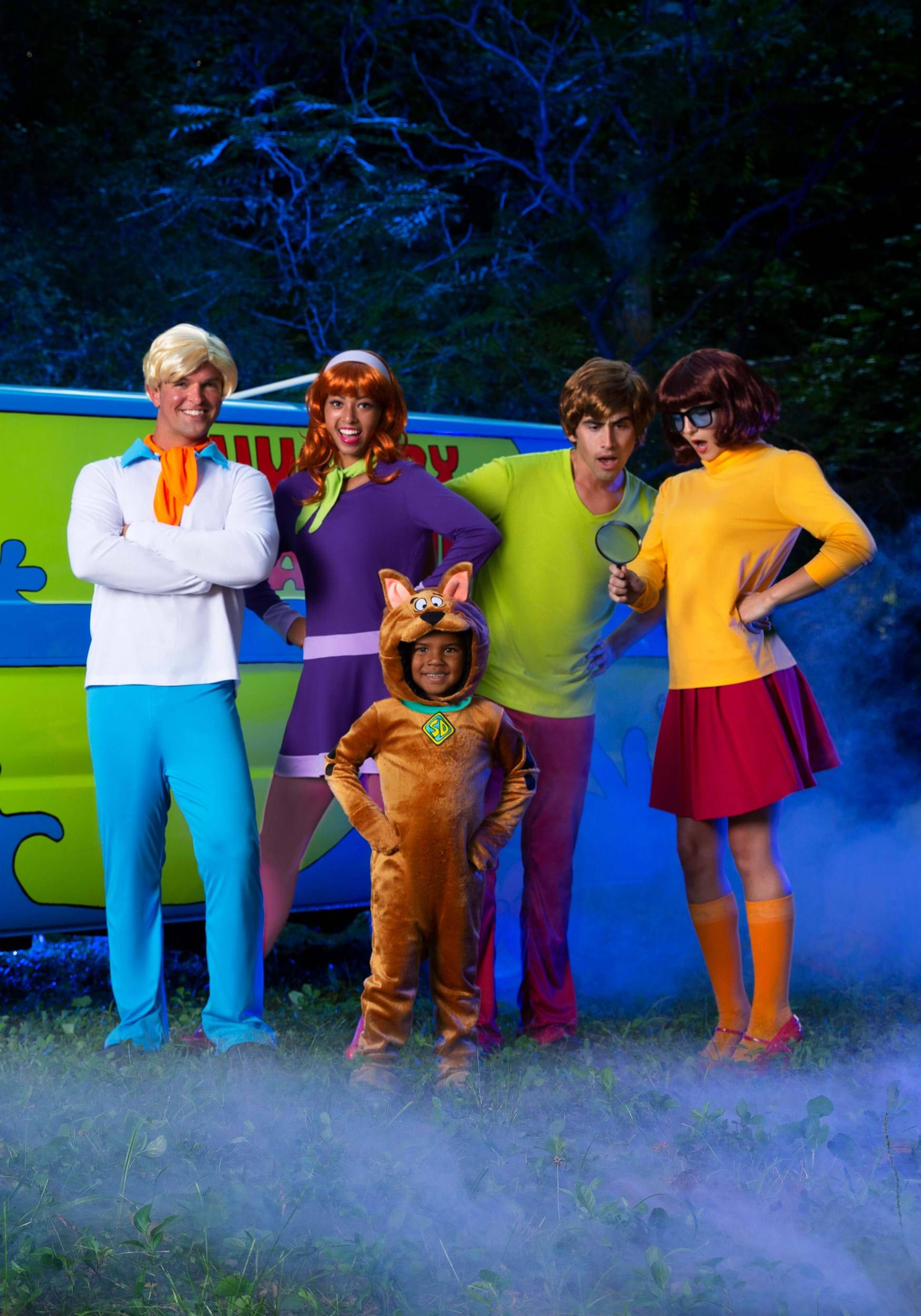 Scooby 桌布 壁紙 — 五個穿著戲服的史酷比幫成員在詭異的藍色迷霧中自信地擺姿勢站在神秘機器前。