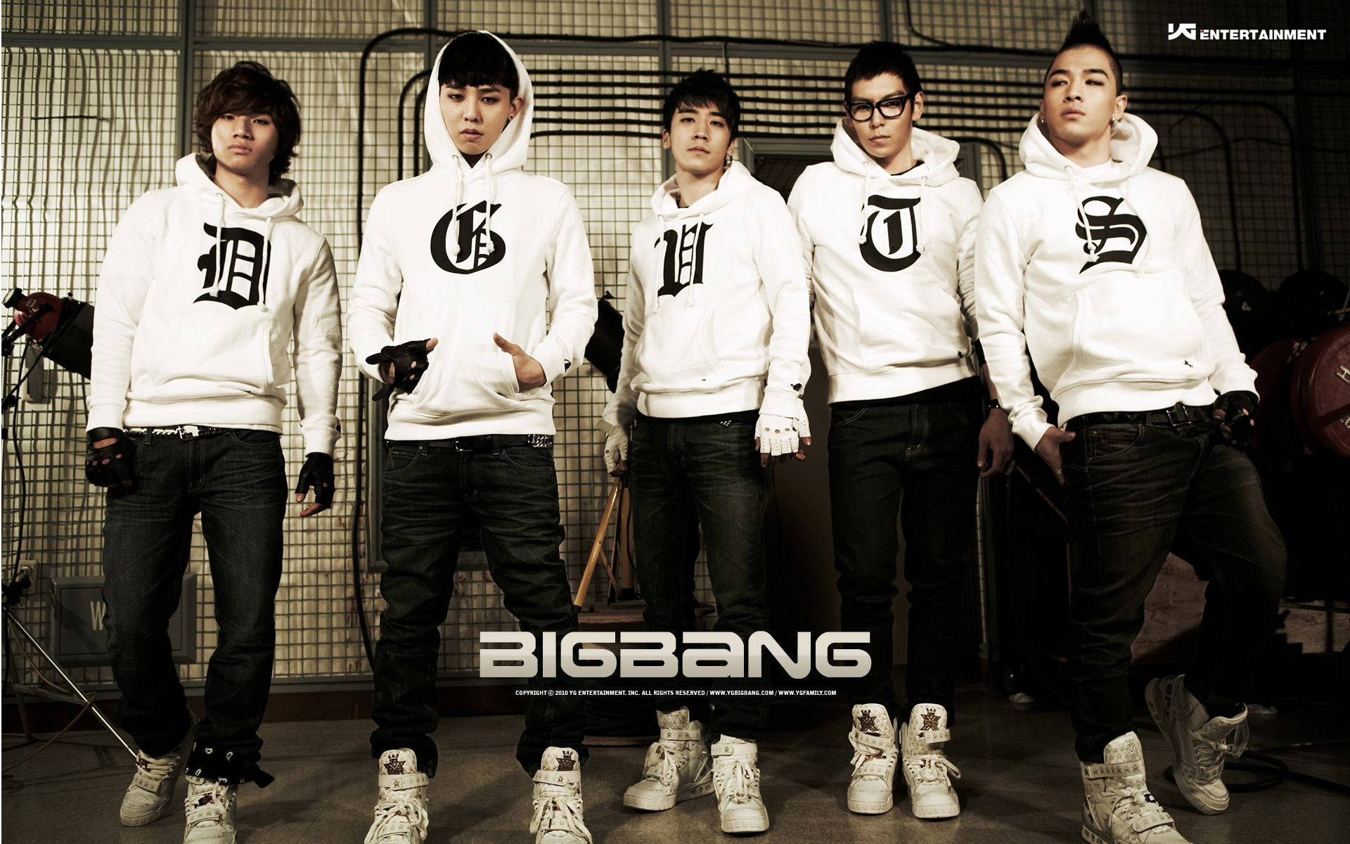 Bigbang 桌布 壁紙 — 五個穿著相配白色連帽衫、帶黑色字體的男人自信地站在粗糙的工業環境中。