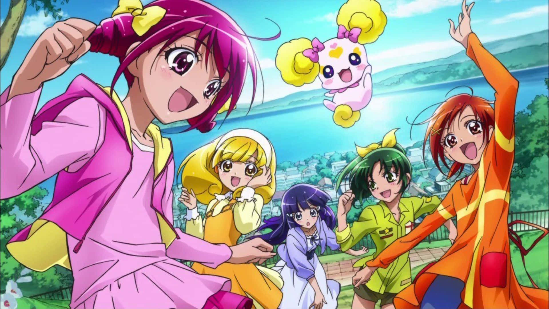 Glitter Force 桌布 壁紙 — 五個穿著色彩繽紛服裝的開朗動畫女孩在明亮的藍天下與一個漂浮的粉紅色生物一起充滿活力地擺姿勢。
