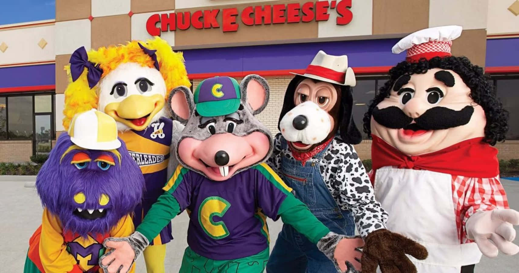 查克芝士 桌布 壁紙 — 五個色彩繽紛的Chuck E Cheese吉祥物在燈火通明的餐廳建築外愉快地擺姿勢。