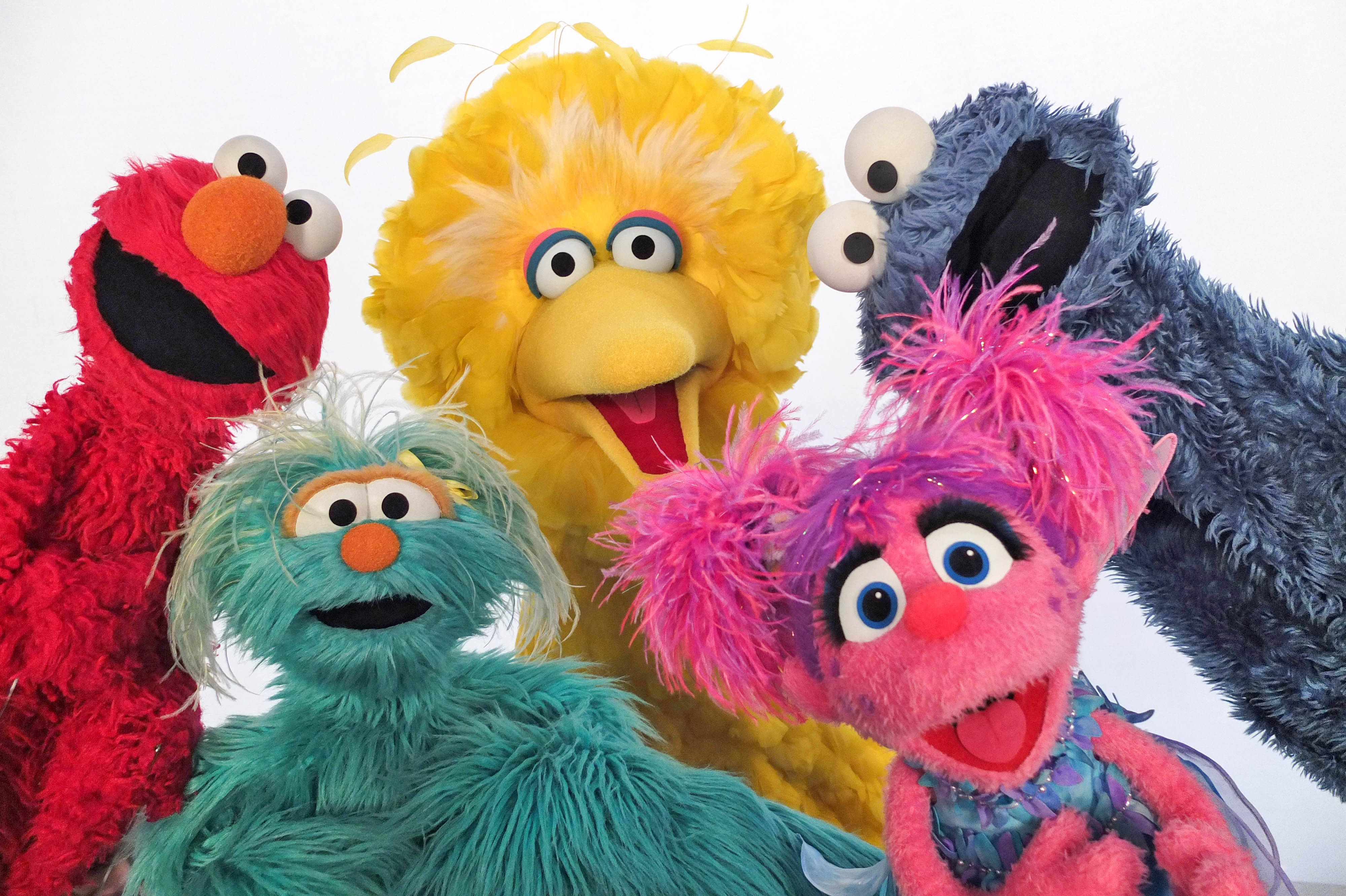 Sesame Street 桌布 壁紙 — 五個色彩繽紛的芝麻街布偶：艾摩、大鳥、餅乾怪獸、艾比卡達比和葛羅弗，在純白背景前燦爛微笑。