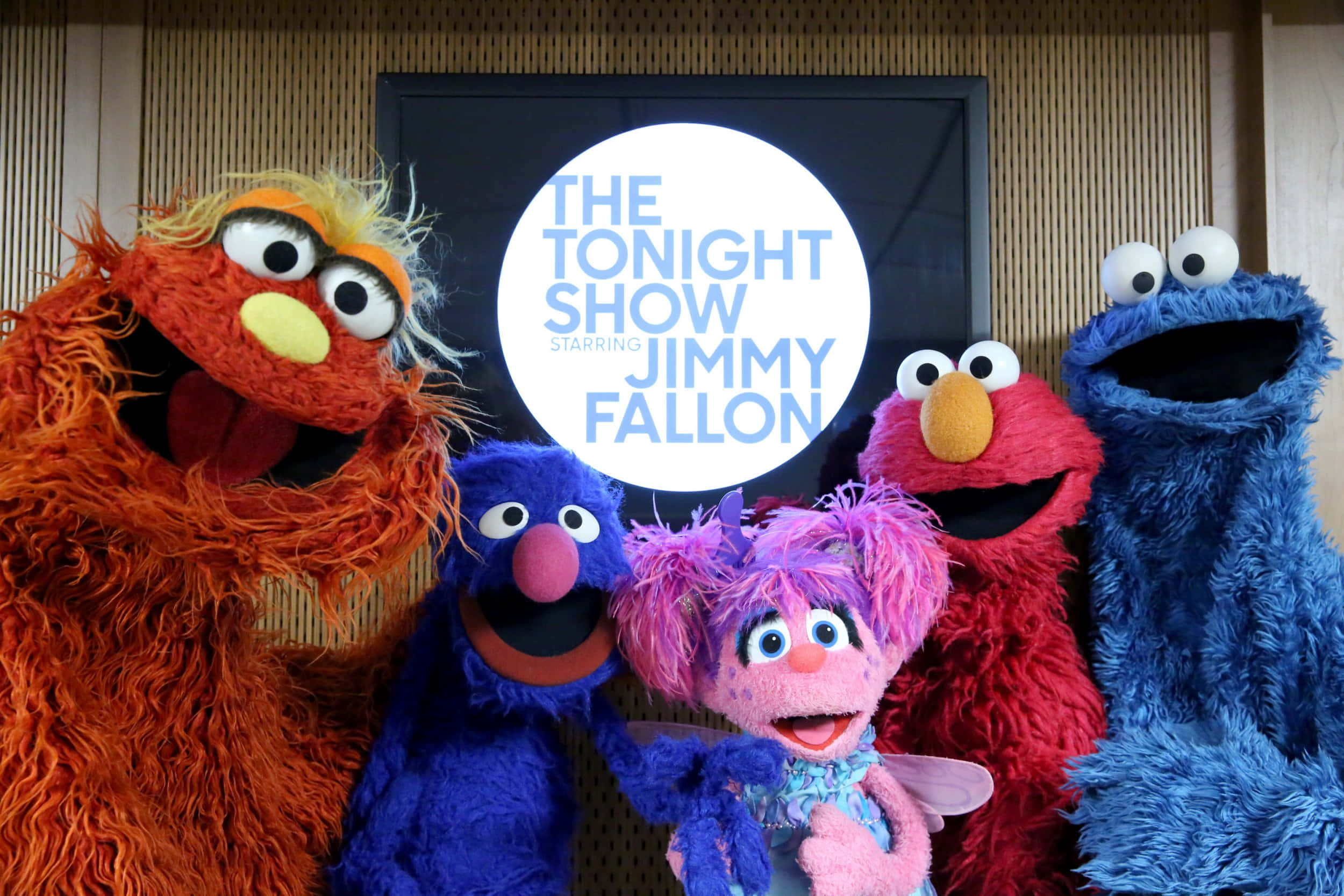 Elmo 桌布 壁紙 — 五個色彩繽紛的芝麻街布偶在 Tonight Show 標誌前愉快地擺姿勢。