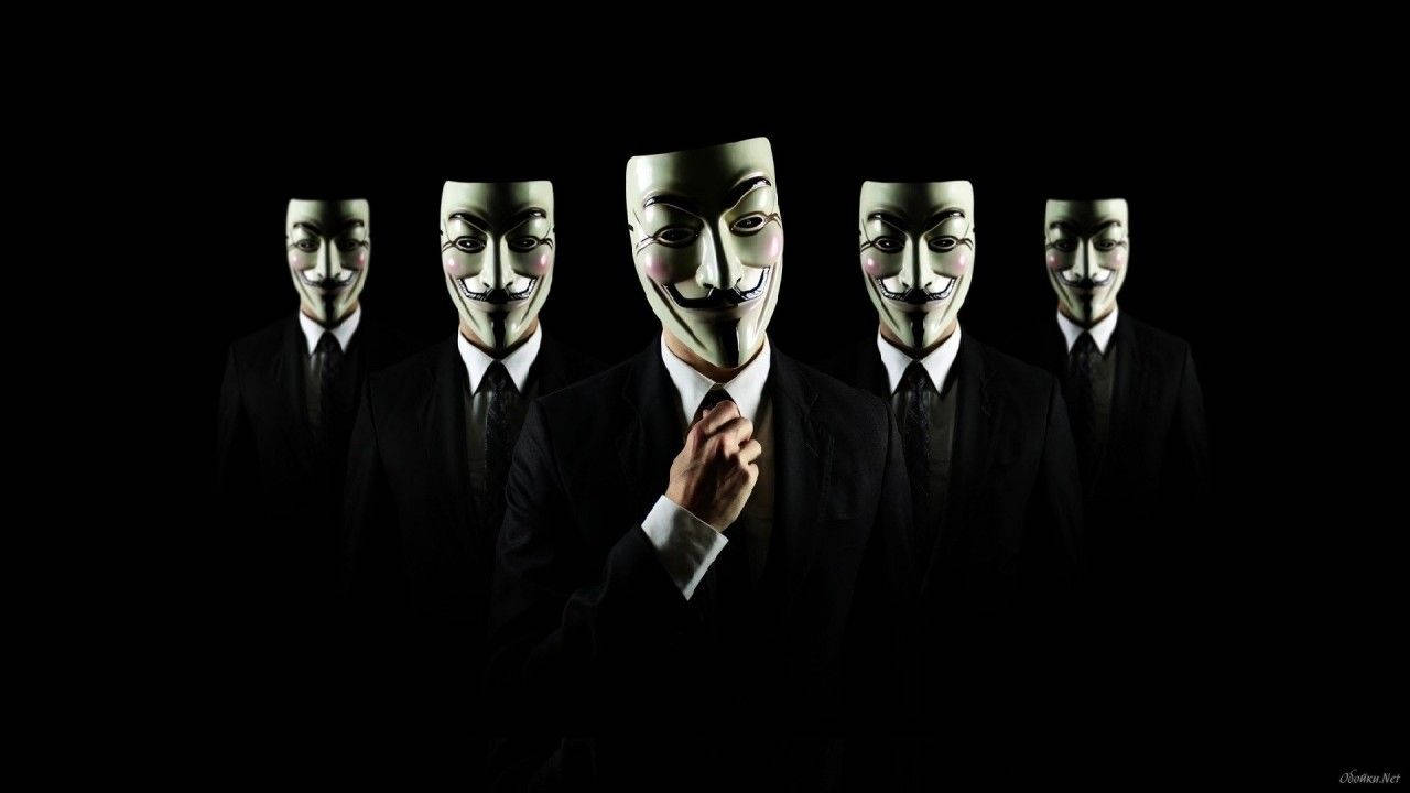 Facebook 桌布 壁紙 — 五個身穿黑色西裝、戴著白色 Guy Fawkes 面具的人物在黑暗背景前站成一排，中間的人物正在調整領帶。