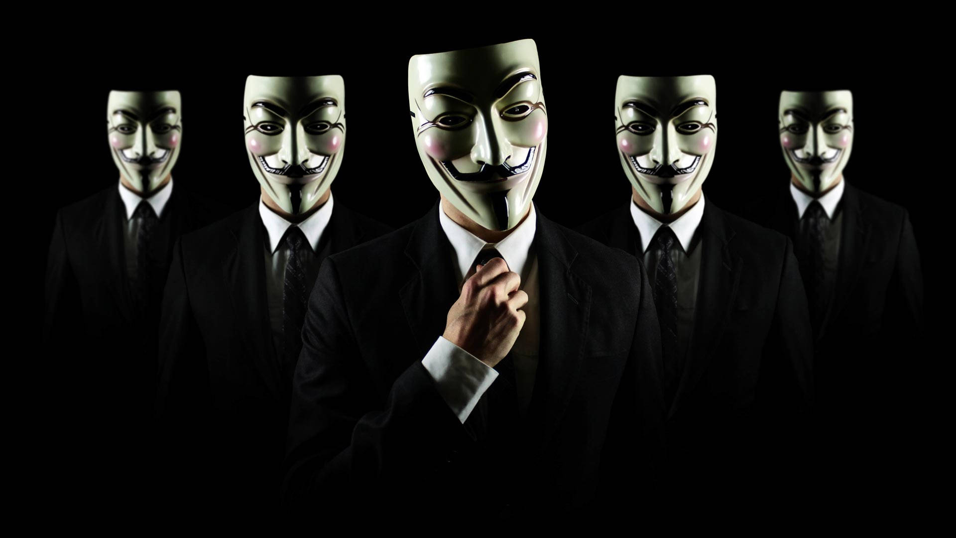 Hacker Full HD 桌布 壁紙 — 五個身穿黑色西裝的人物在純黑色背景前戴著標誌性的綠色 Guy Fawkes 面具。
