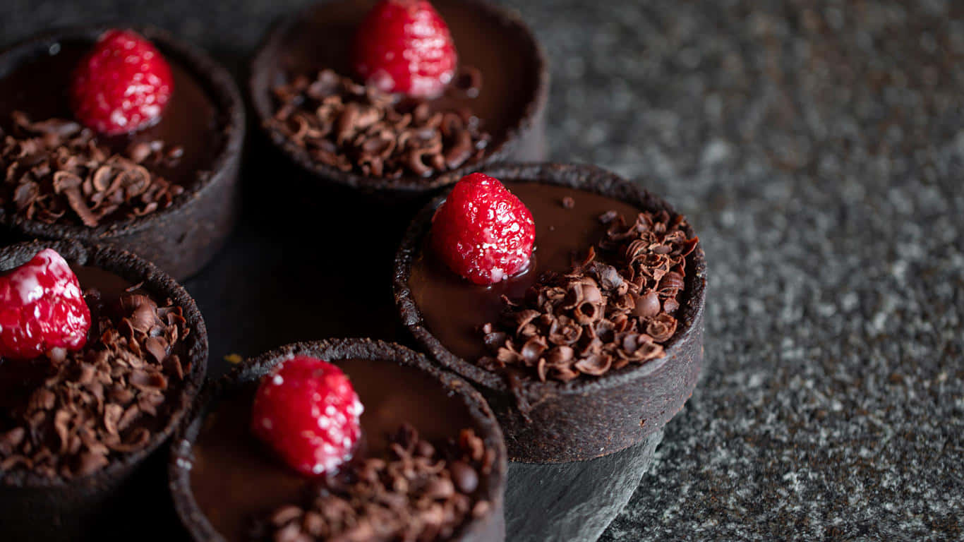 1366x768 Desserts 桌布 壁紙 — 五個頹廢的巧克力撻，上面放上新鮮覆盆子和巧克力刨花，放在深色石面上。