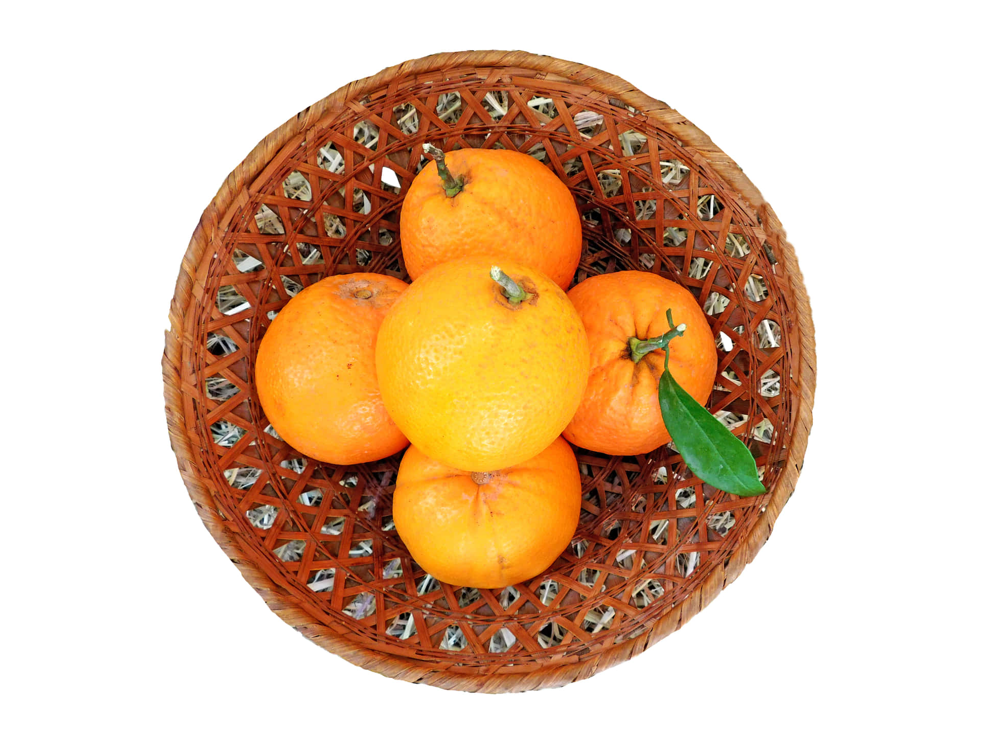 Oranges 壁紙 — 五個鮮豔的柳橙配上一片綠葉，放在一個編織的棕色竹籃裡，背景是純白色。
