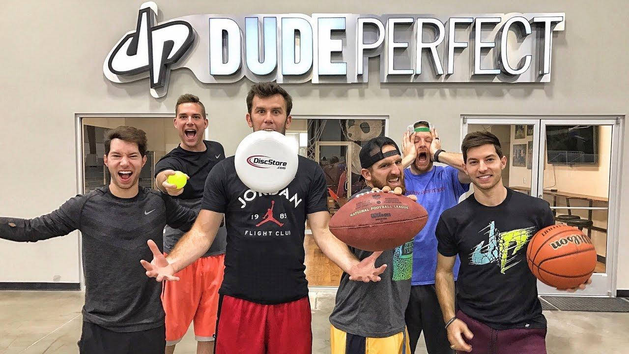 籃球 桌布 壁紙 — 五名男子在攝影棚內於Dude Perfect標誌下充滿活力地擺出姿勢，手持運動裝備。
