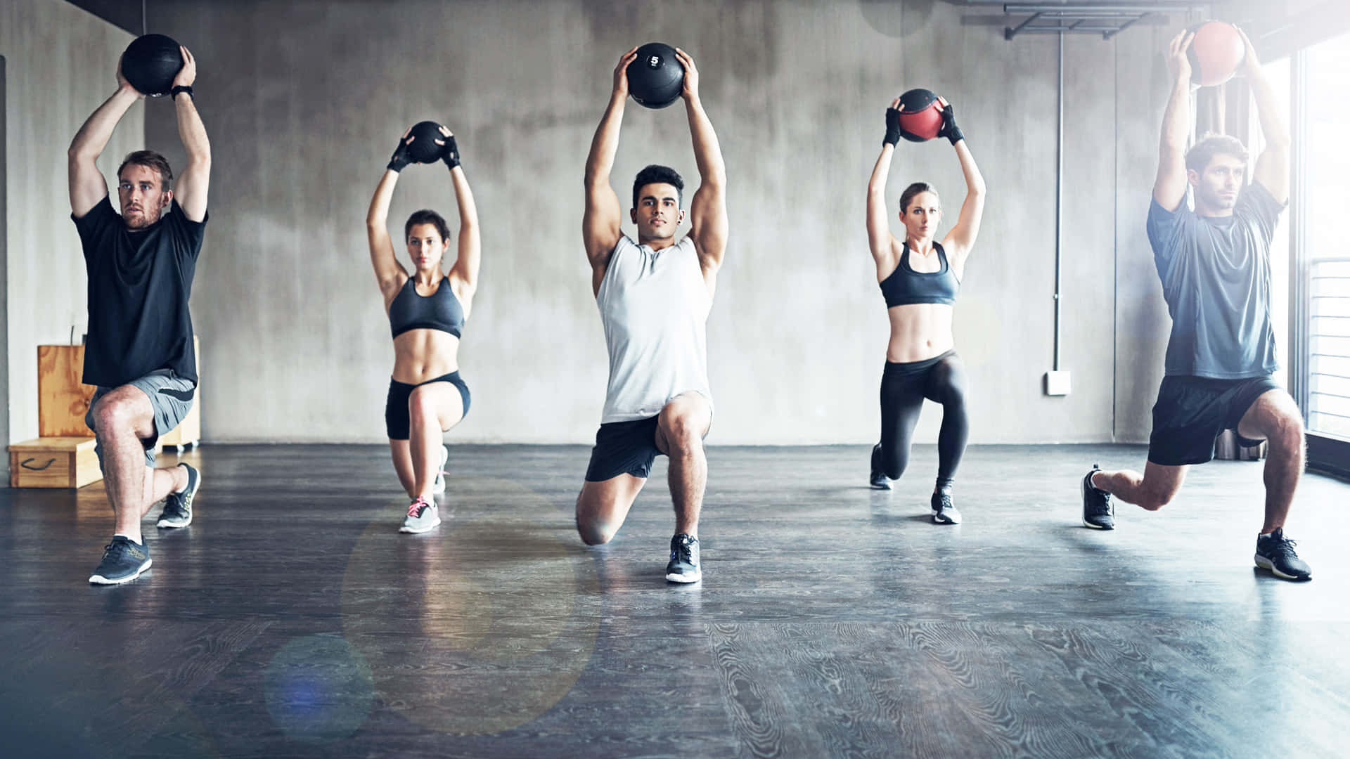 健身 桌布 壁紙 — 五名穿著運動服的運動員在一個極簡風格的健身房（混凝土牆壁和木地板）中進行同步的壺鈴弓步蹲。