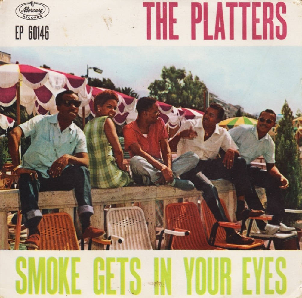 Album Cover 桌布 壁紙 — 五名身穿1960年代服裝的男子在陽光普照的戶外露臺上，在有圖案的遮陽傘下休閒地躺著。